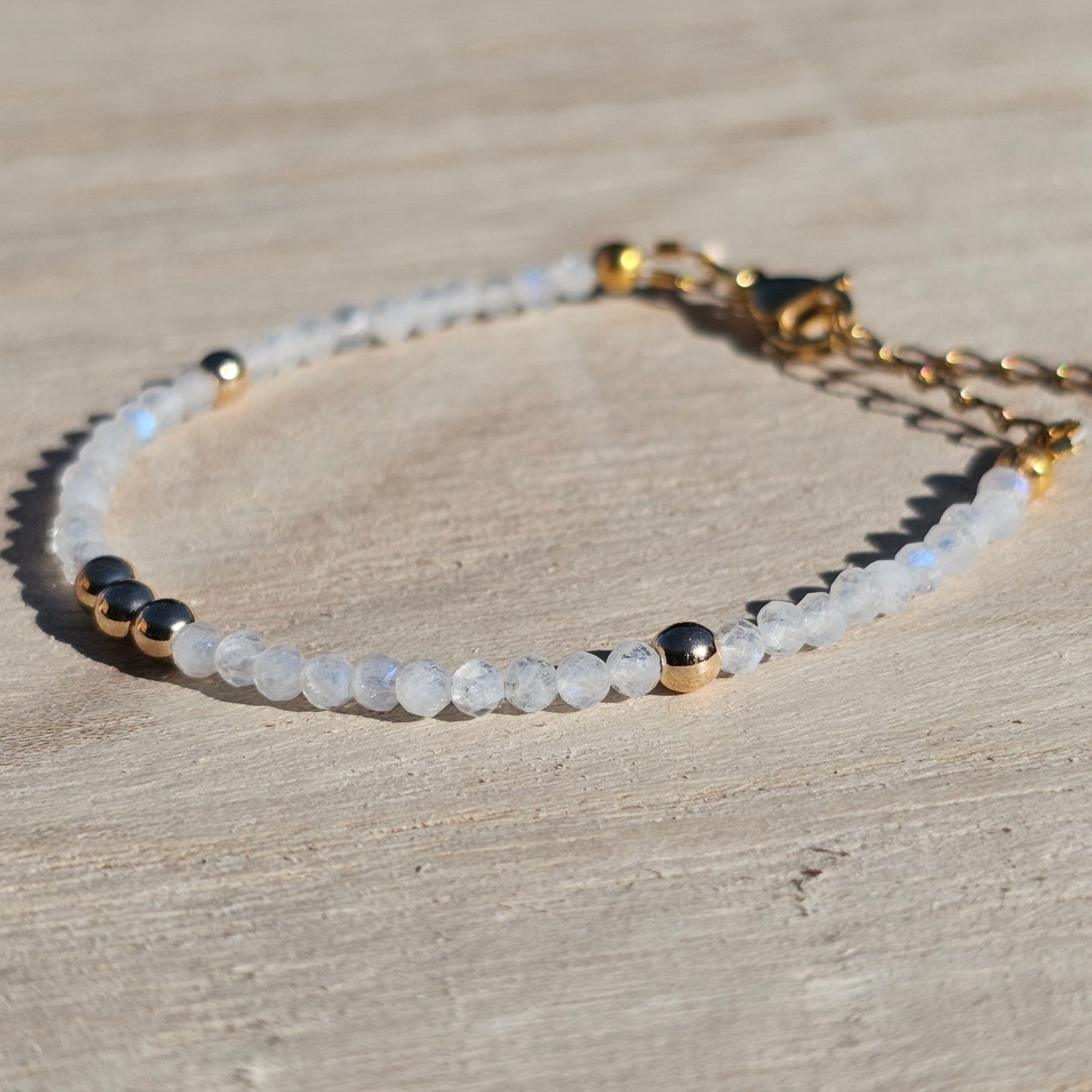 Delicate, faceted dainty AAA grade Rainbow Moonstone and AAA grade gold plated Hematite bead bracelet with a gold stainless steel clasp and extender chain.