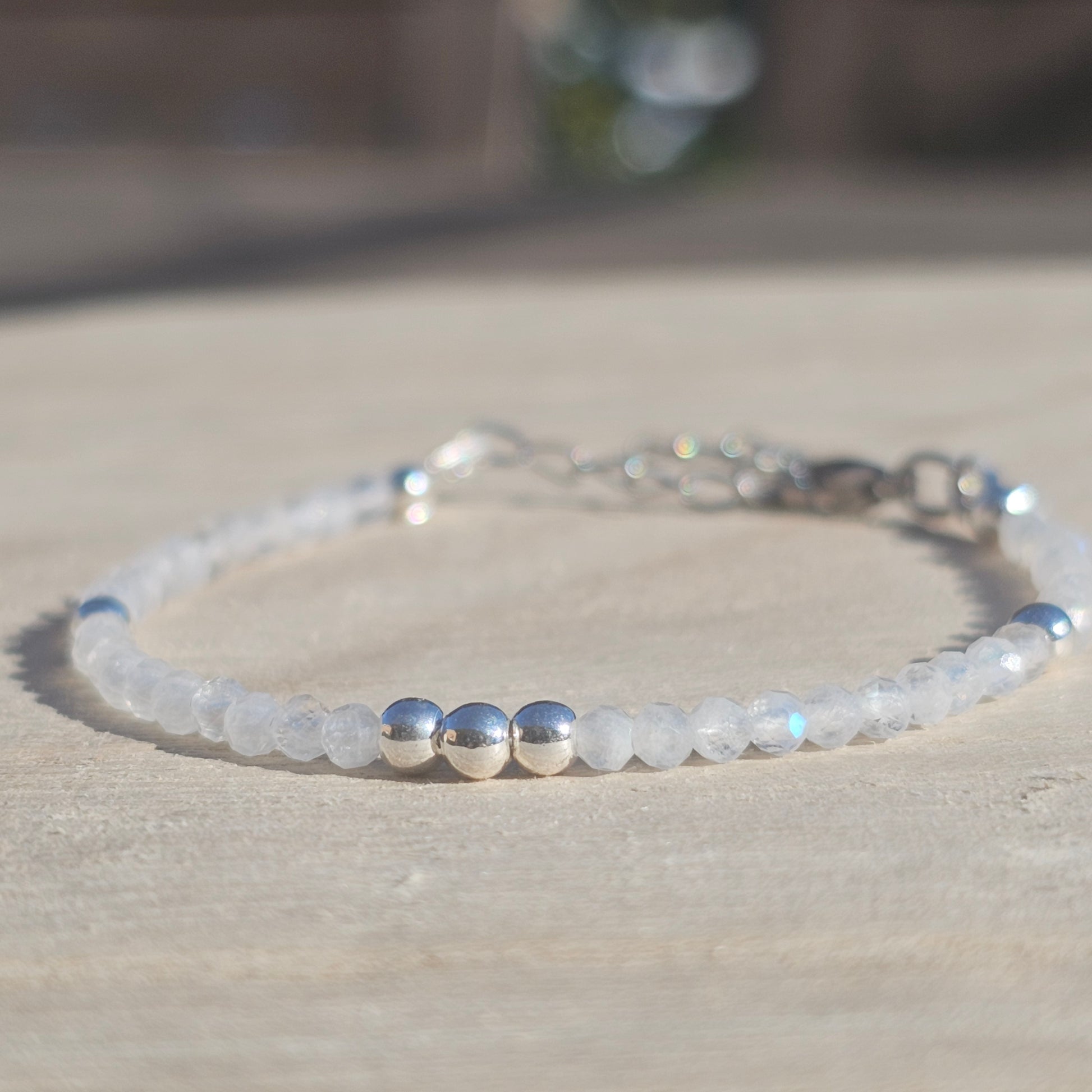 Delicate, faceted dainty AAA grade Rainbow Moonstone and AAA grade silver plated Hematite bead bracelet with a silver stainless steel clasp and extender chain.