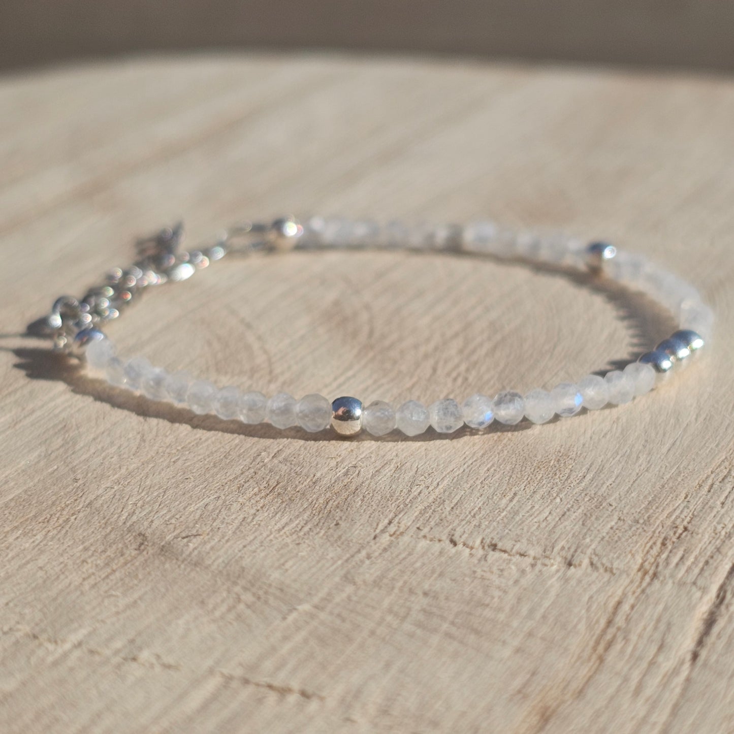 Delicate, faceted dainty AAA grade Rainbow Moonstone and AAA grade silver plated Hematite bead bracelet with a silver stainless steel clasp and extender chain.