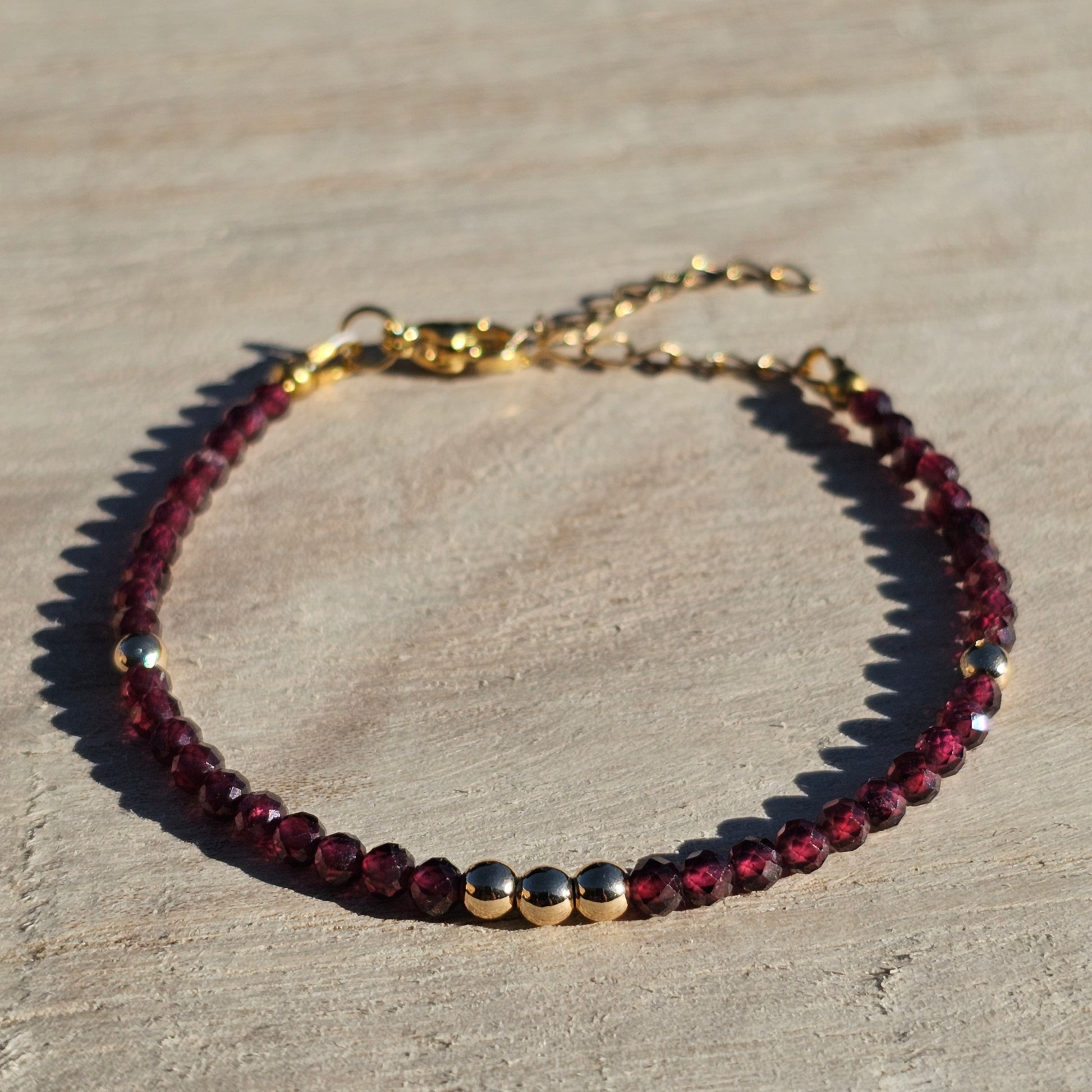 Delicate, faceted dainty AA grade Garnet and AAA grade gold plated Hematite bead bracelet with a gold stainless steel clasp and extender chain.