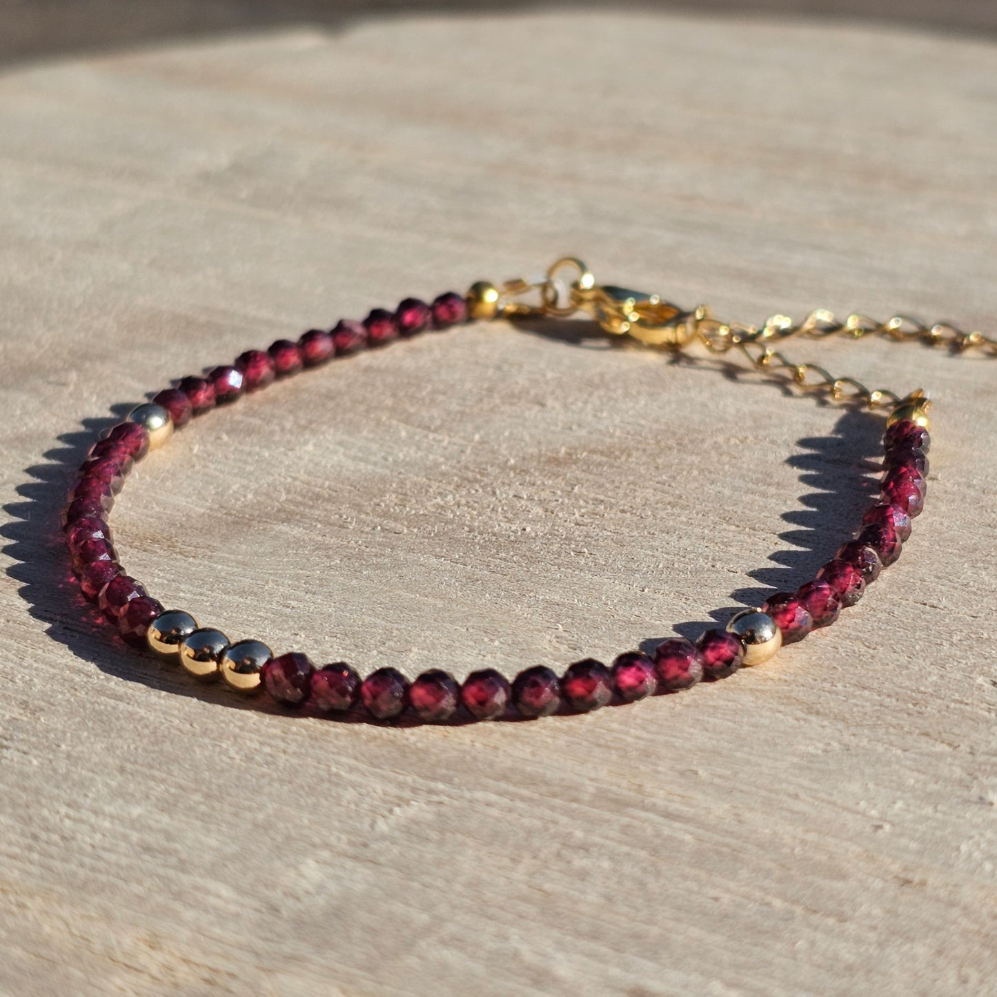 Delicate, faceted dainty AA grade Garnet and AAA grade gold plated Hematite bead bracelet with a gold stainless steel clasp and extender chain.