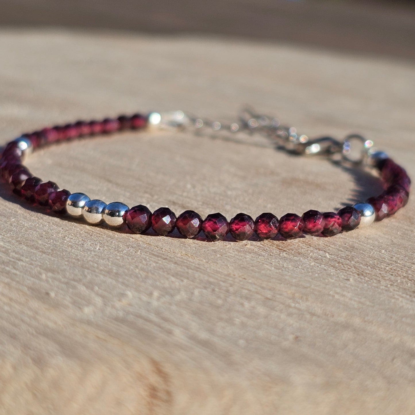 Delicate, faceted dainty AA grade Garnet and AAA grade silver plated Hematite bead bracelet with a silver stainless steel clasp and extender chain.