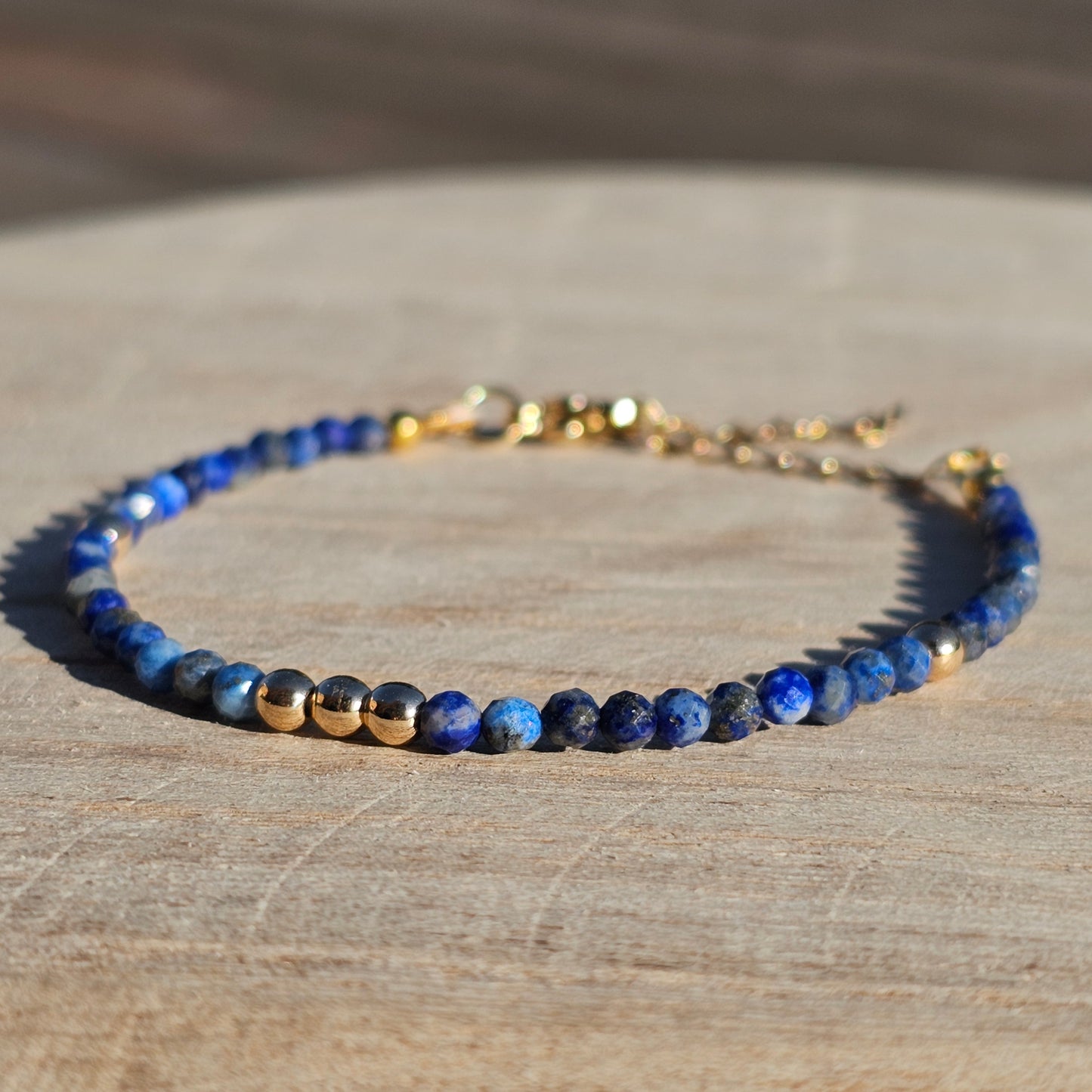 Delicate, faceted dainty AA grade Lapis Lazuli and AAA grade gold plated Hematite bead bracelet with a gold stainless steel clasp and extender chain.