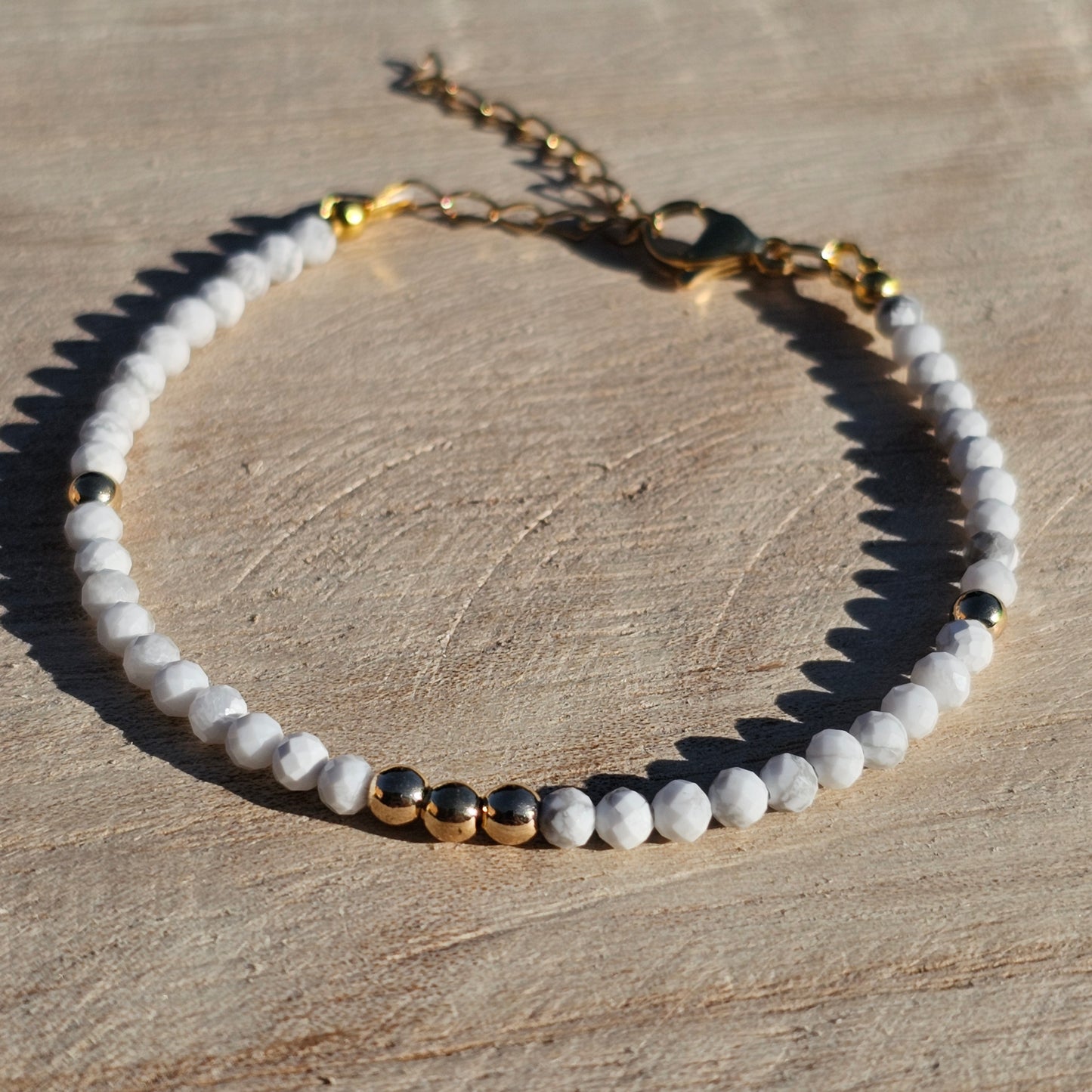 Delicate, faceted dainty AA grade Howlite and AAA grade gold plated Hematite bead bracelet with a gold stainless steel clasp and extender chain.