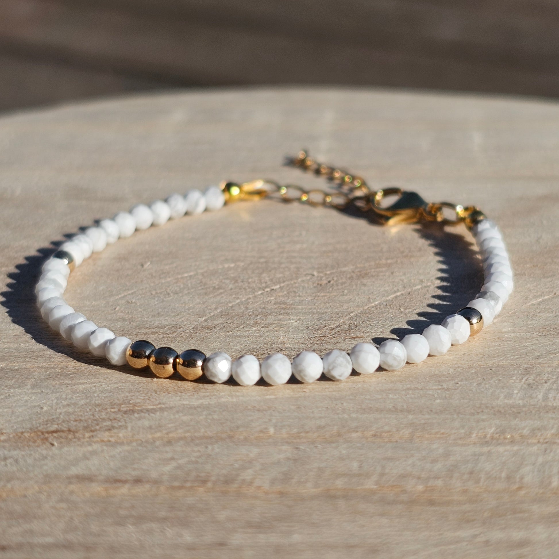 Delicate, faceted dainty AA grade Howlite and AAA grade gold plated Hematite bead bracelet with a gold stainless steel clasp and extender chain.