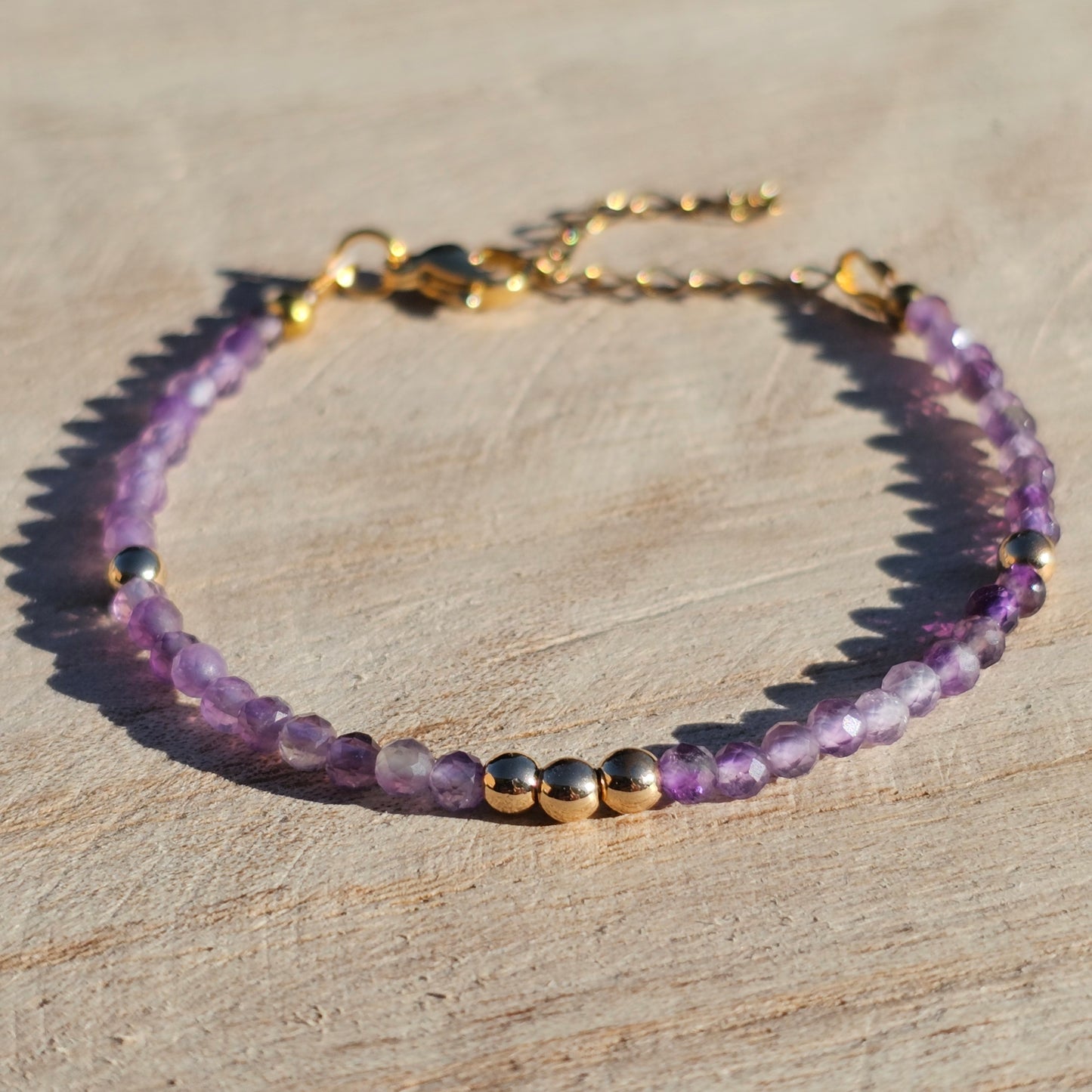 Delicate, faceted dainty AA grade Amethyst and AAA grade gold plated Hematite bead bracelet with a gold stainless steel clasp and extender chain.