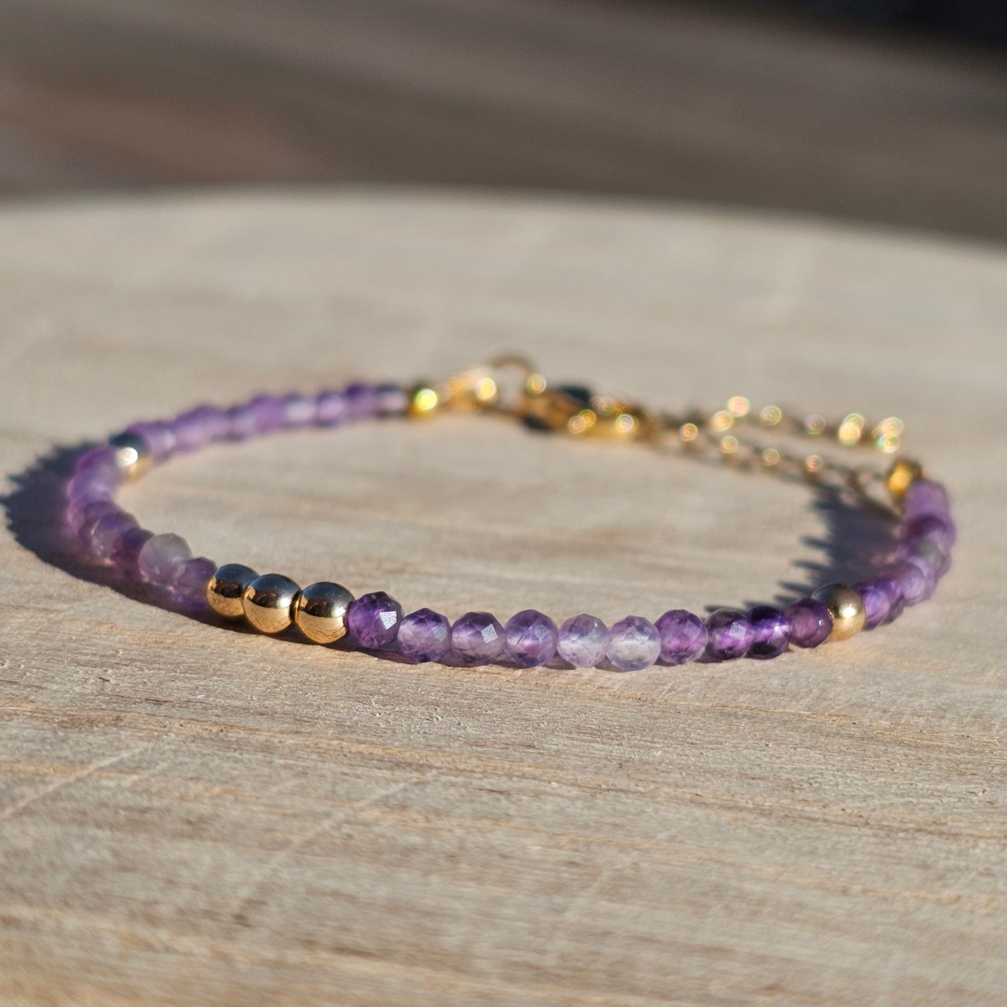 Delicate, faceted dainty AA grade Amethyst and AAA grade gold plated Hematite bead bracelet with a gold stainless steel clasp and extender chain.