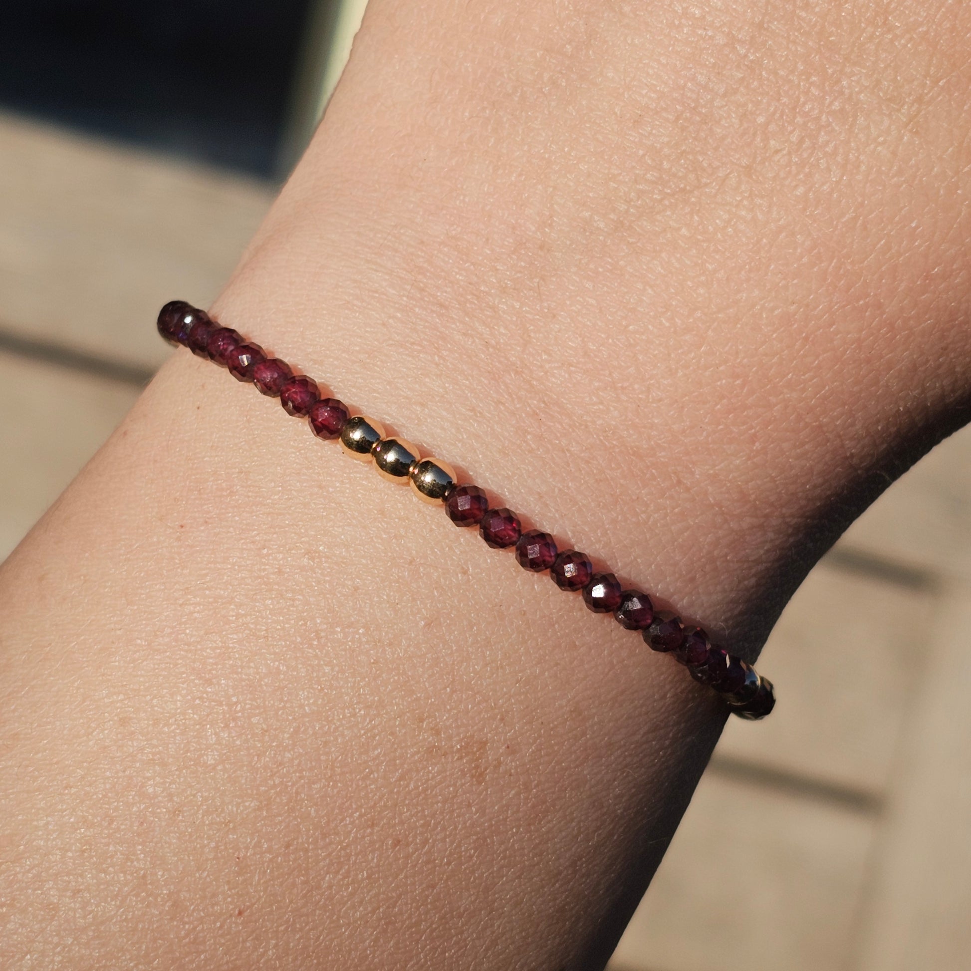 Delicate, faceted dainty AA grade Garnet and AAA grade gold plated Hematite bead bracelet with a gold stainless steel clasp and extender chain.