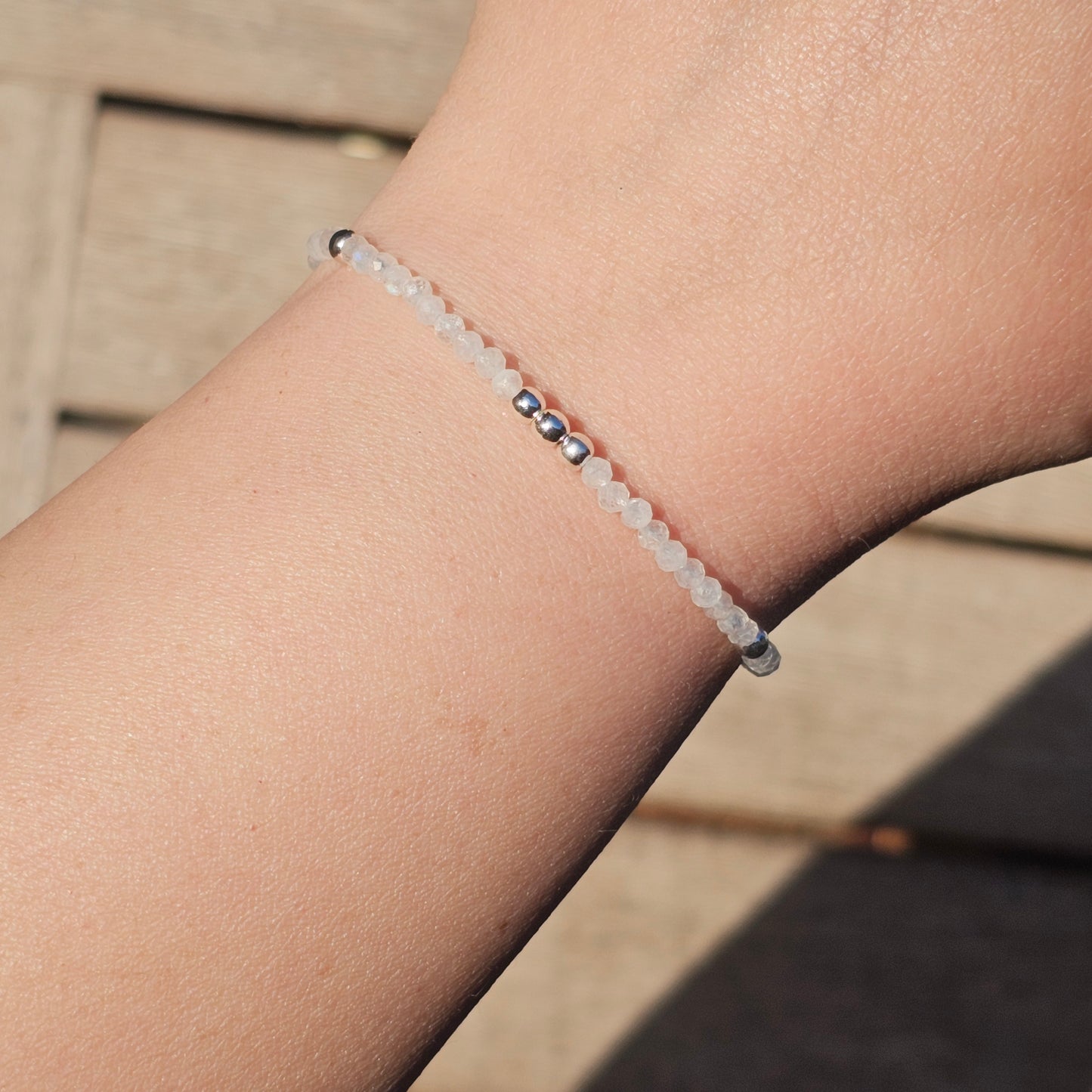 Delicate, faceted dainty AAA grade Rainbow Moonstone and AAA grade silver plated Hematite bead bracelet with a silver stainless steel clasp and extender chain.