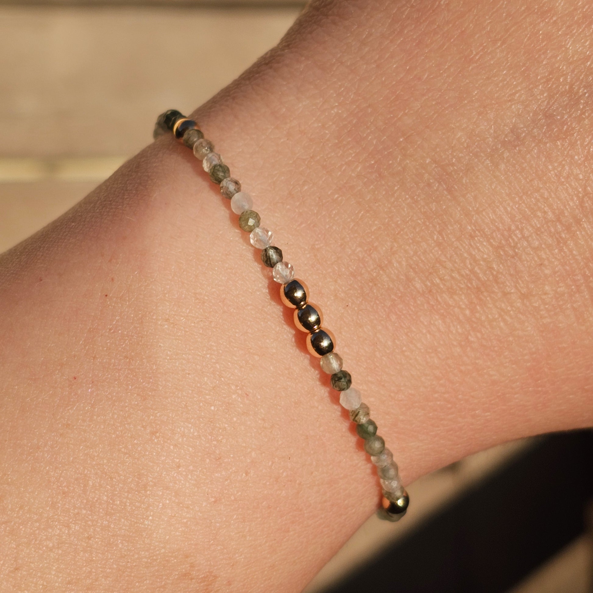 Delicate, faceted dainty green Rutile Quartz and AAA grade gold plated Hematite bead bracelet with a gold stainless steel clasp and extender chain.