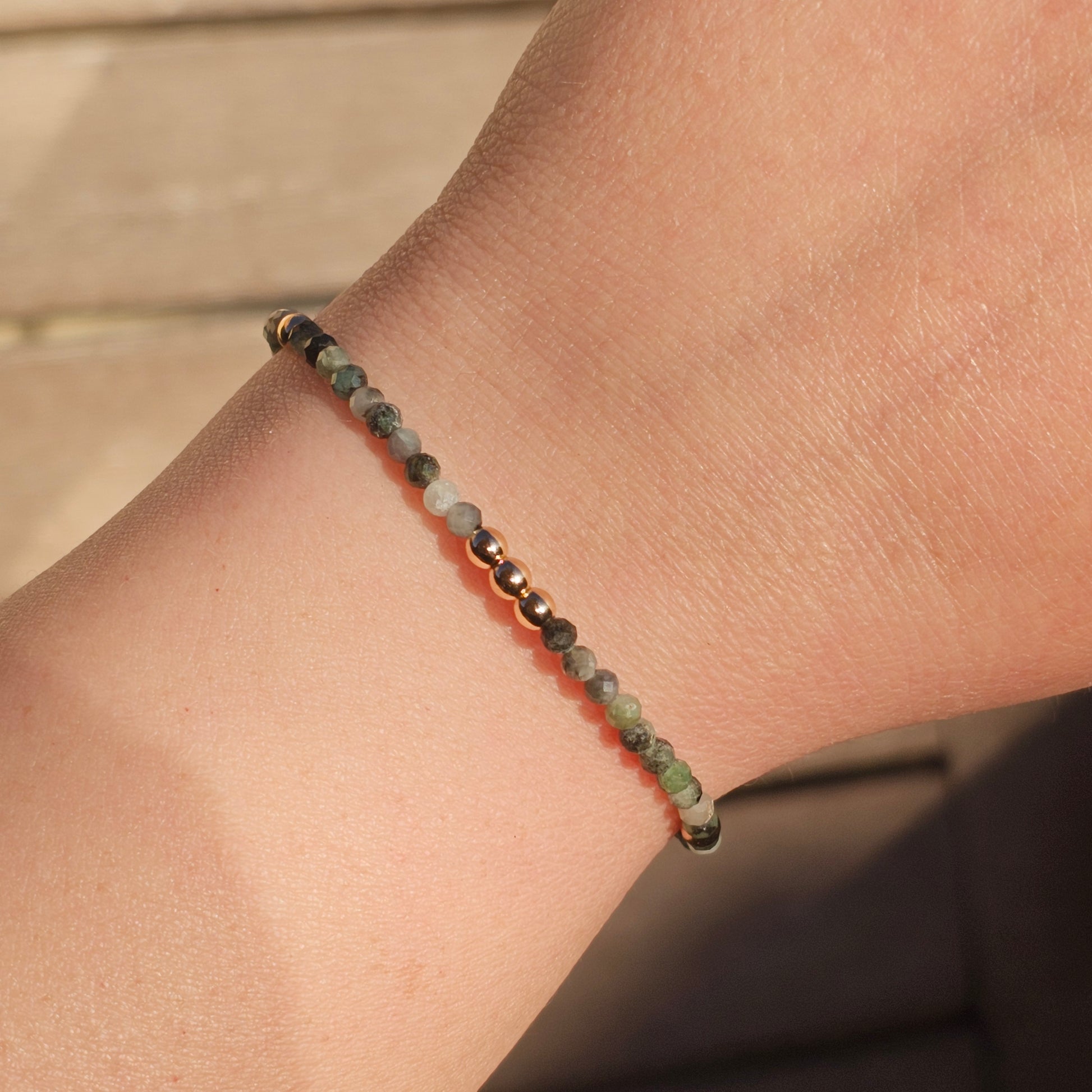 Delicate, faceted dainty Emerald and AAA grade gold plated Hematite bead bracelet with a gold stainless steel clasp and extender chain.