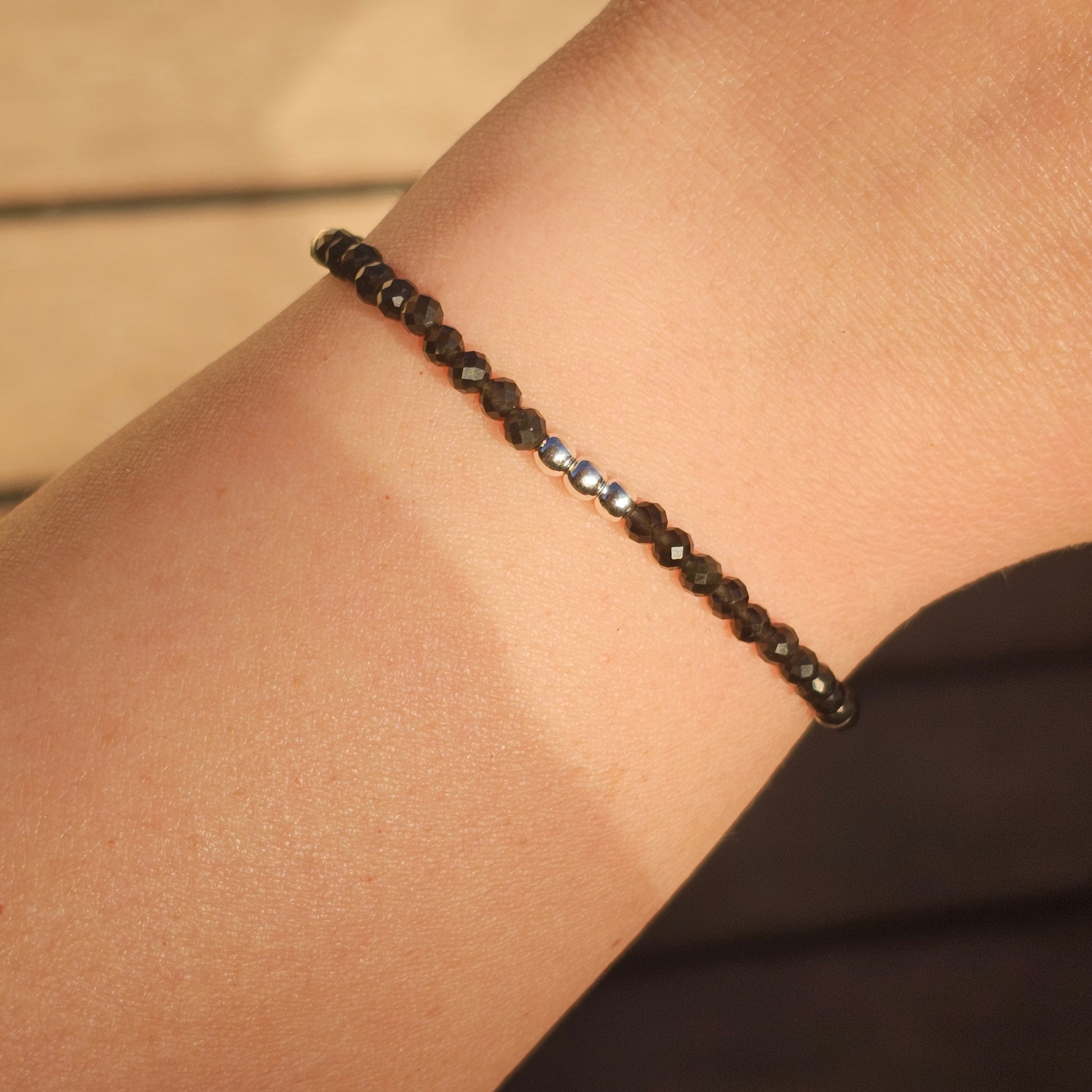 Delicate, faceted dainty Obsidian and AAA grade silver plated Hematite bead bracelet with a silver stainless steel clasp and extender chain.