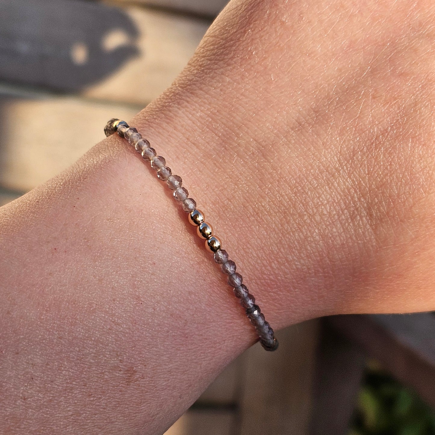 Delicate, faceted dainty Smoky Quartz and AAA grade gold plated Hematite bead bracelet with a gold stainless steel clasp and extender chain.