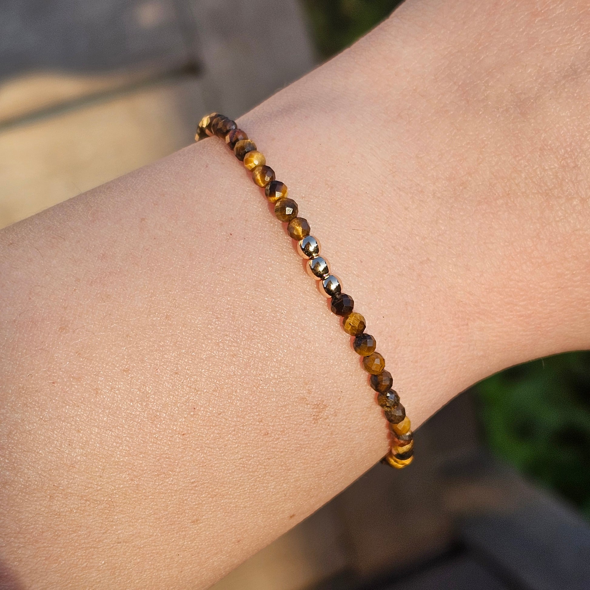 Delicate, faceted dainty Tiger's Eye and AAA grade gold plated Hematite bead bracelet with a gold stainless steel clasp and extender chain.