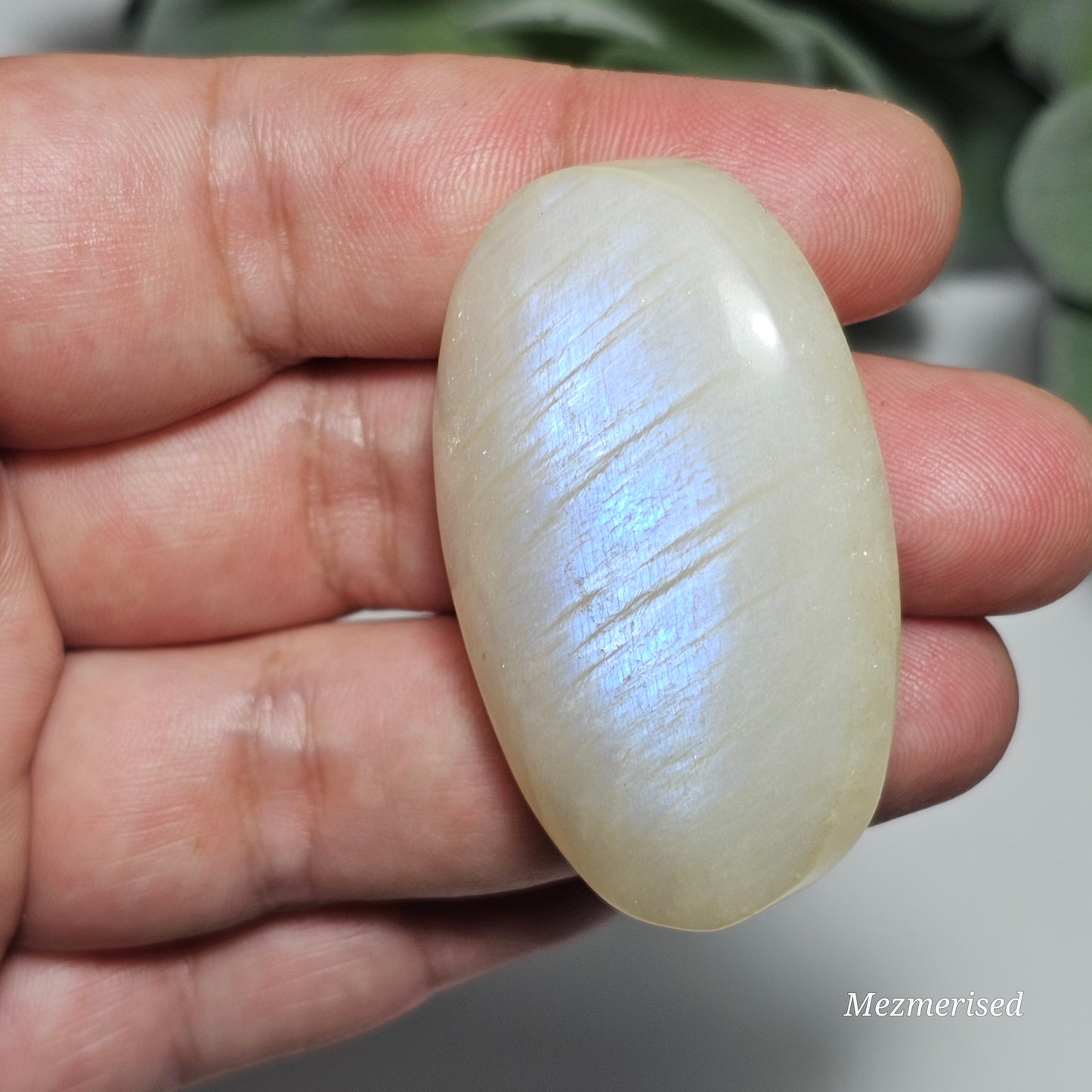 Small sized Rainbow Moonstone palm stone with a beautiful blue flash.