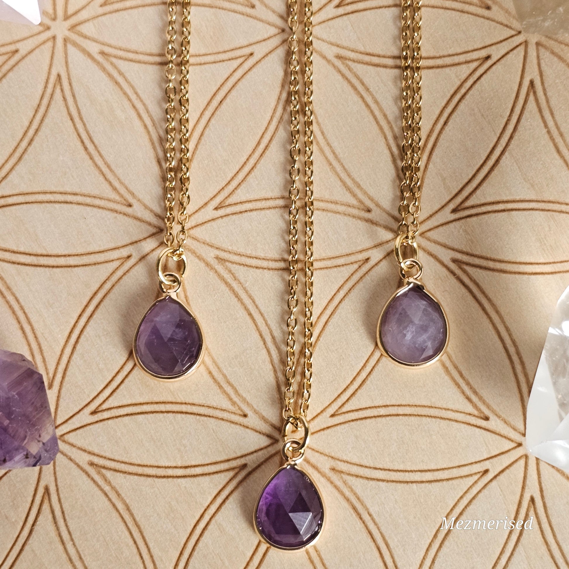 Faceted Amethyst teardrop pendant suspended from a gold coloured stainless steel chain.