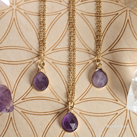 Faceted Amethyst teardrop pendant suspended from a gold coloured stainless steel chain.