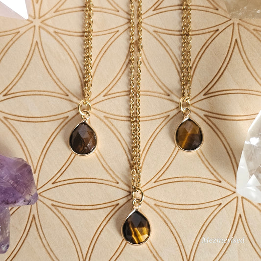 Faceted Tiger's Eye teardrop pendant suspended from a gold coloured stainless steel chain.