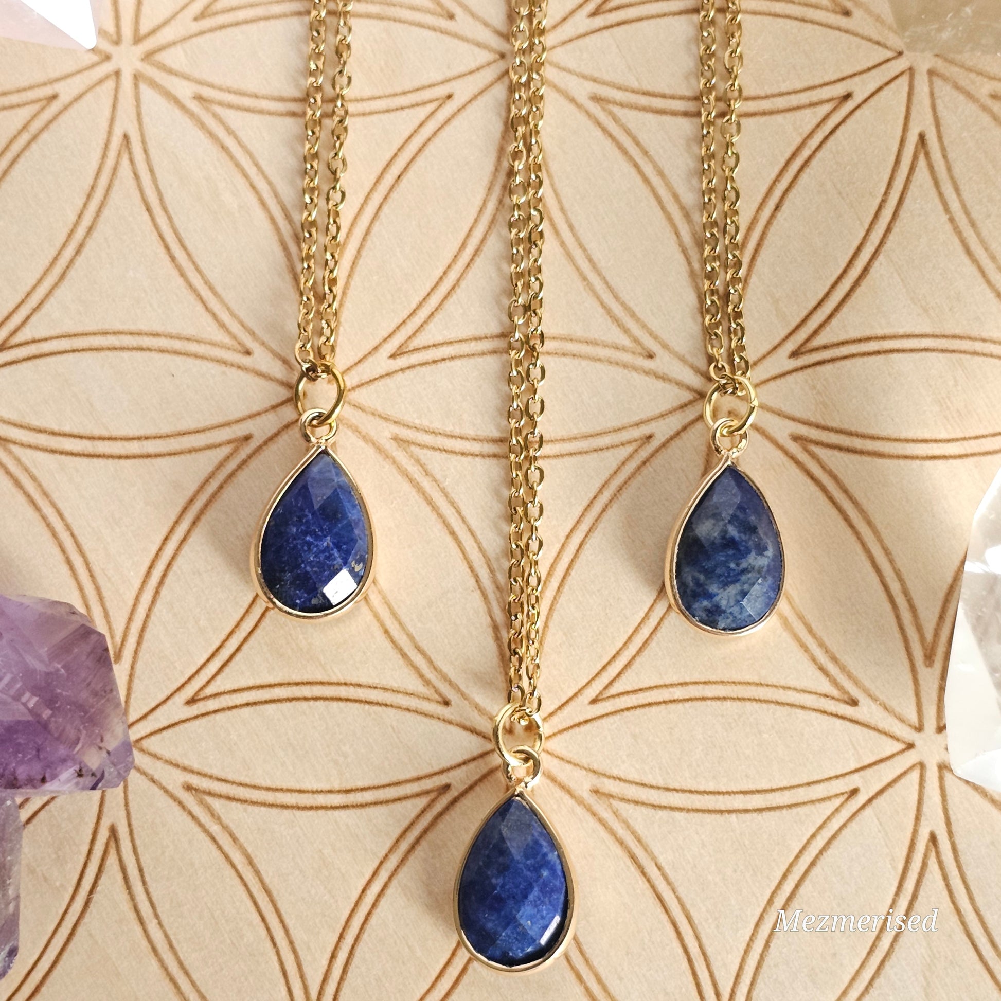 Faceted Lapis Lazuli puffy teardrop pendant suspended from a gold coloured stainless steel chain.