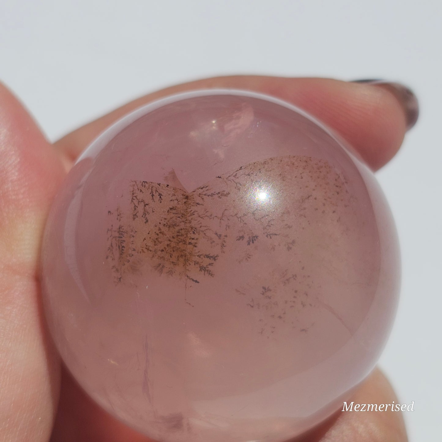 A stunning Rose Quartz sphere with asterism, beautiful rainbows, and gorgeous dendritic inclusions