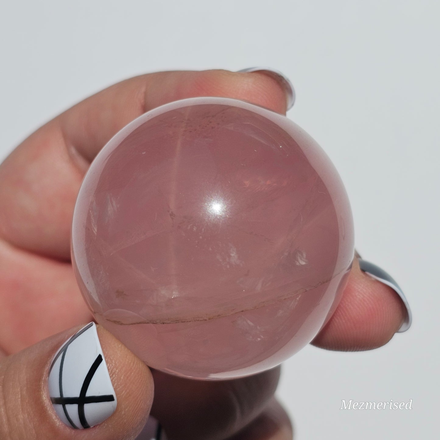 A stunning Rose Quartz sphere with asterism, beautiful rainbows, and gorgeous dendritic inclusions