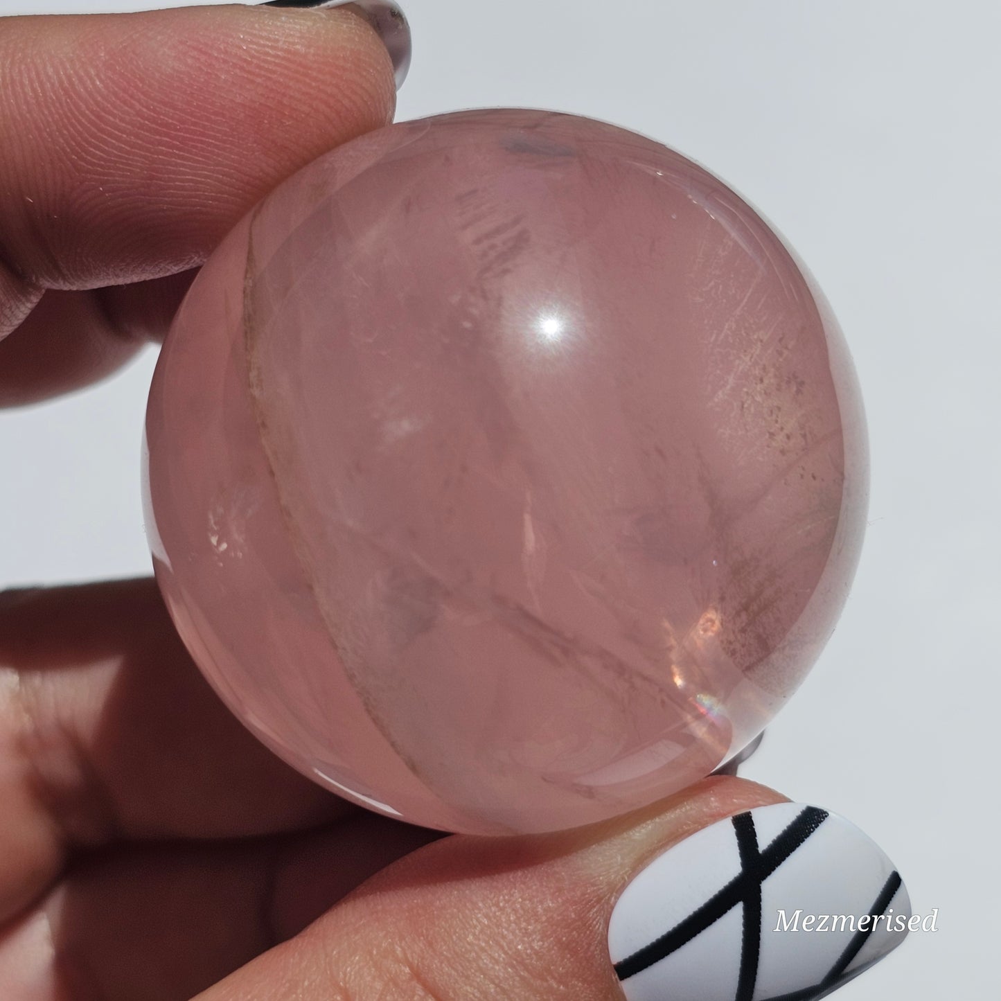 A stunning Rose Quartz sphere with asterism, beautiful rainbows, and gorgeous dendritic inclusions