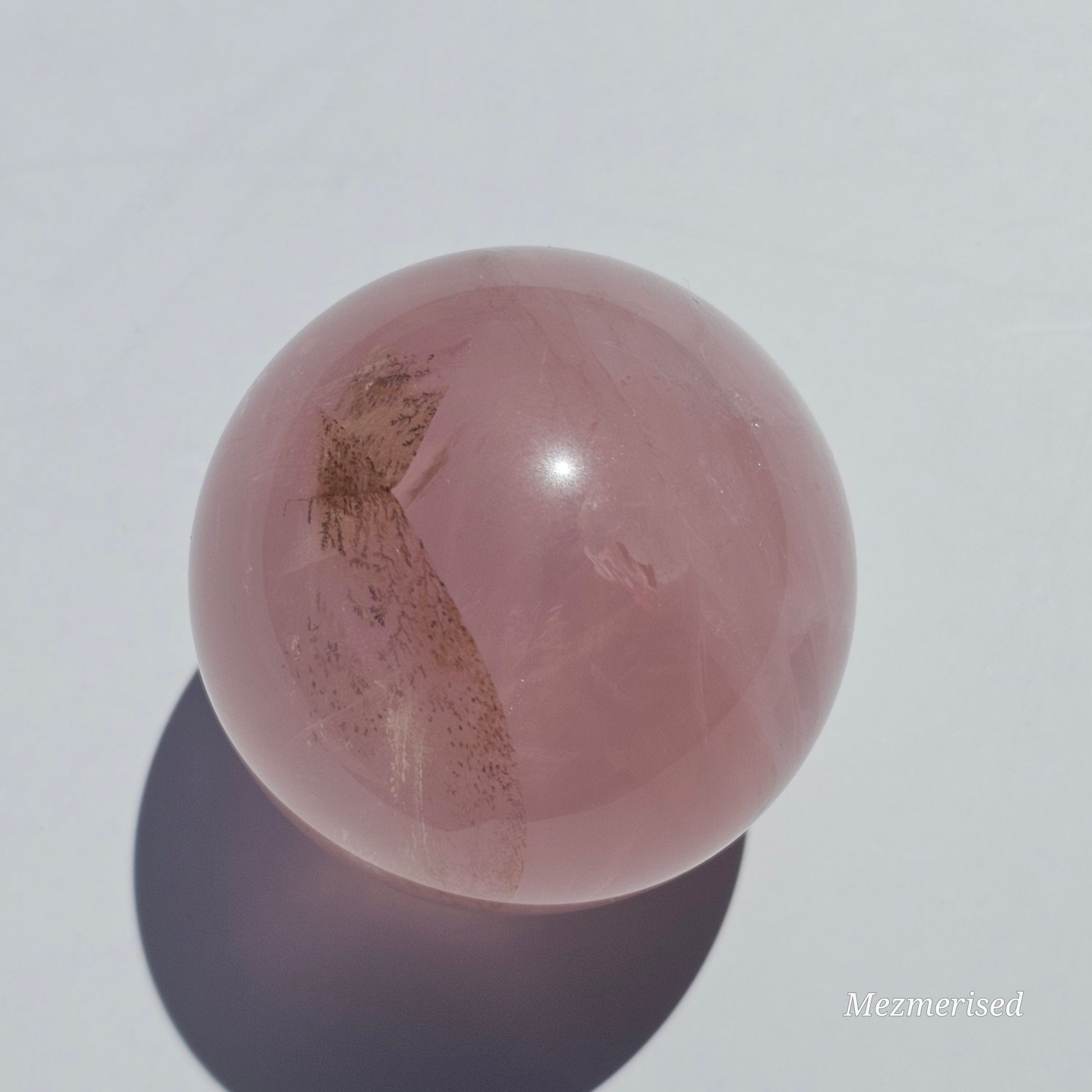 A stunning Rose Quartz sphere with asterism, beautiful rainbows, and gorgeous dendritic inclusions