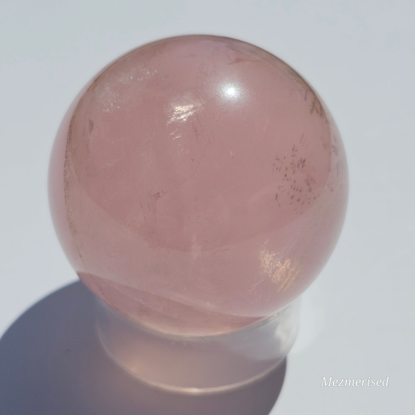 A stunning Rose Quartz sphere with asterism, beautiful rainbows, and gorgeous dendritic inclusions