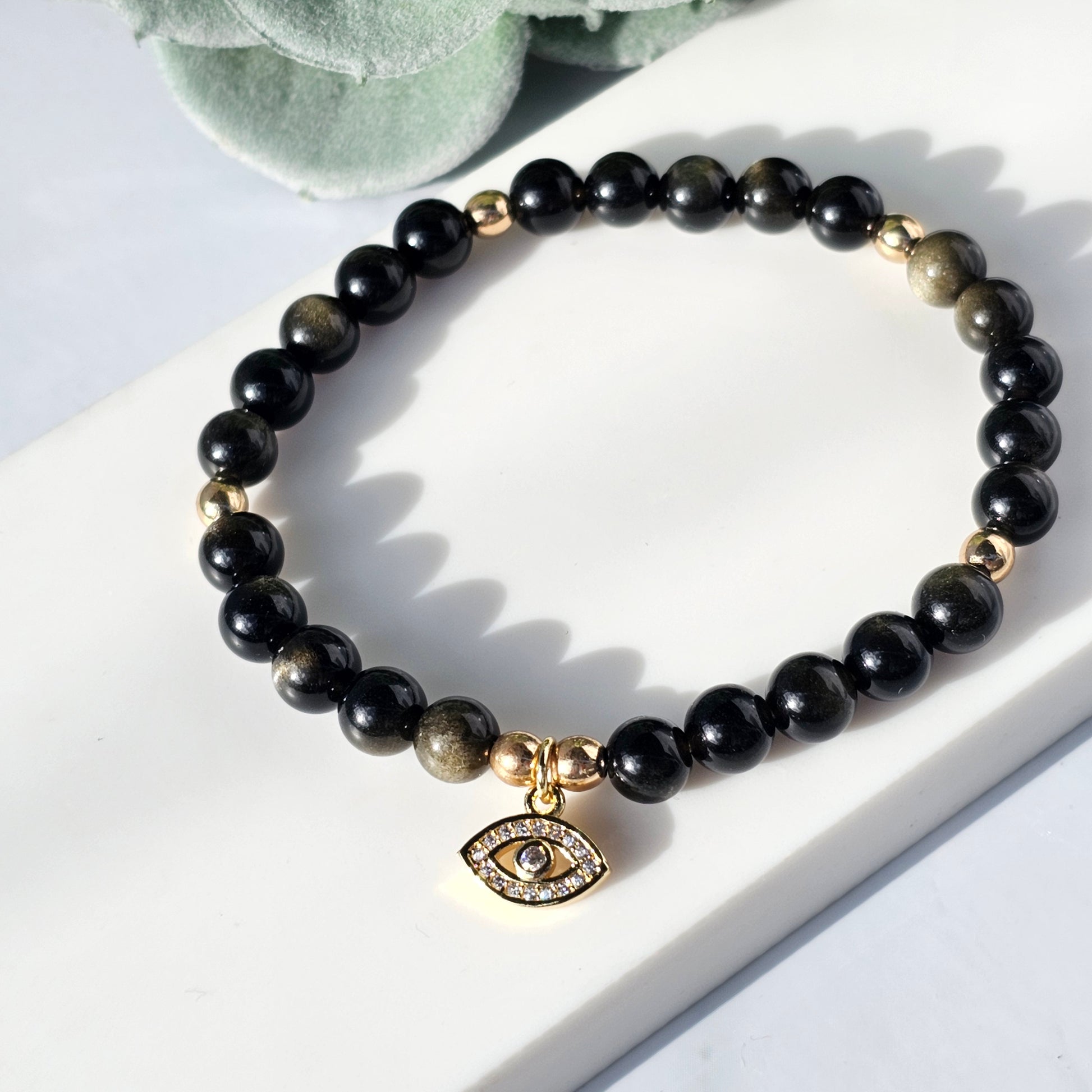 gold sheen obsidian bracelet with an eye charm