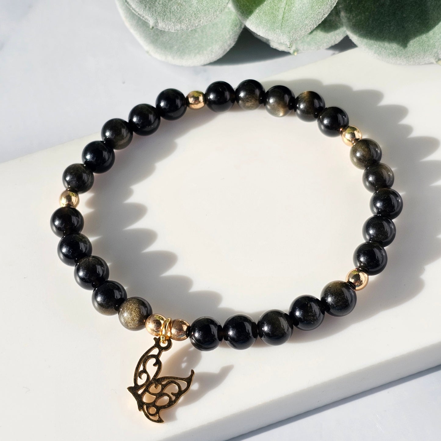 gold sheen obsidian bracelet with a butterfly charm
