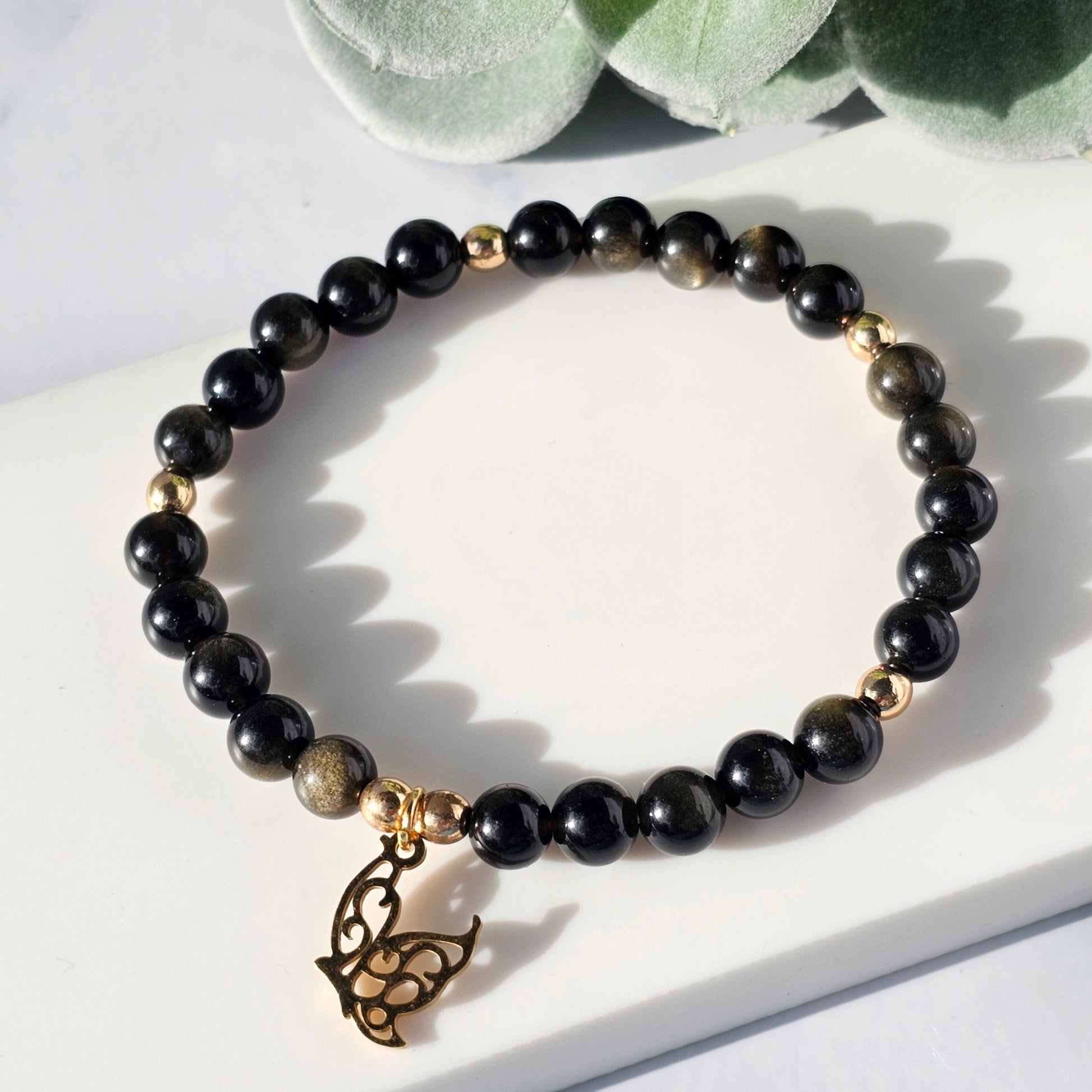 gold sheen obsidian bracelet with a butterfly charm