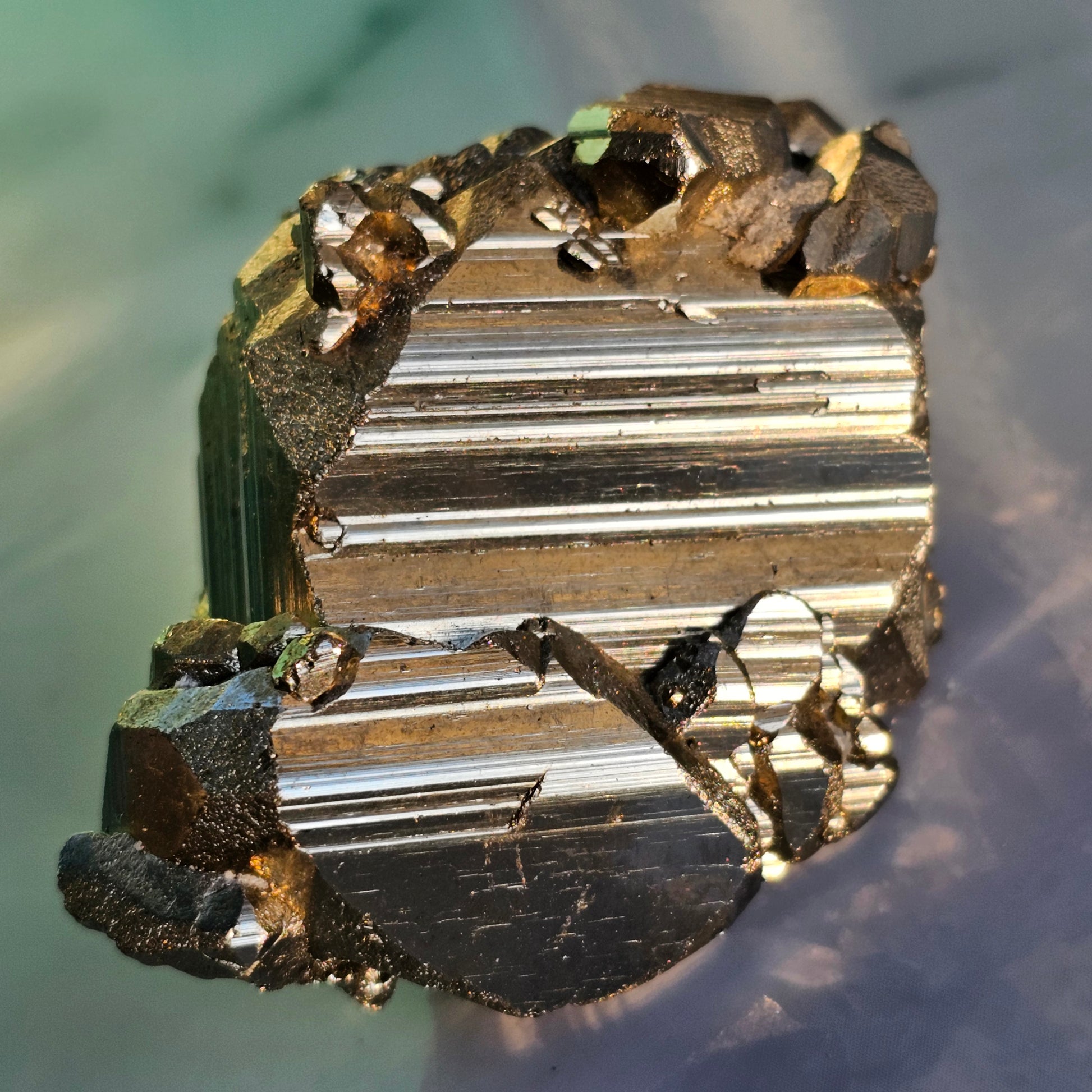 Natural Pyrite cluster in its raw form. This mineral displays a brilliant metallic lustre, with well-defined and sharp parallel striations.