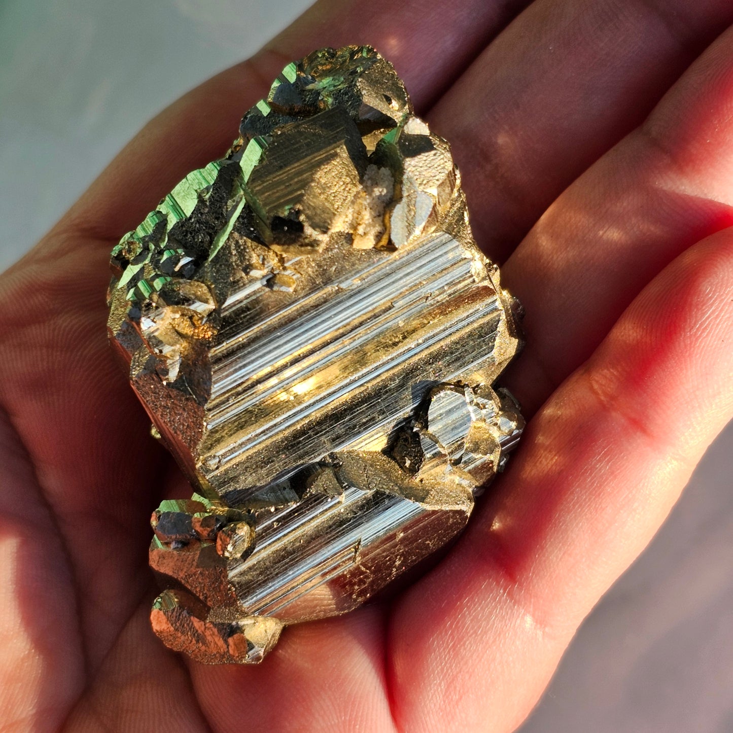 Natural Pyrite cluster in its raw form. This mineral displays a brilliant metallic lustre, with well-defined and sharp parallel striations.