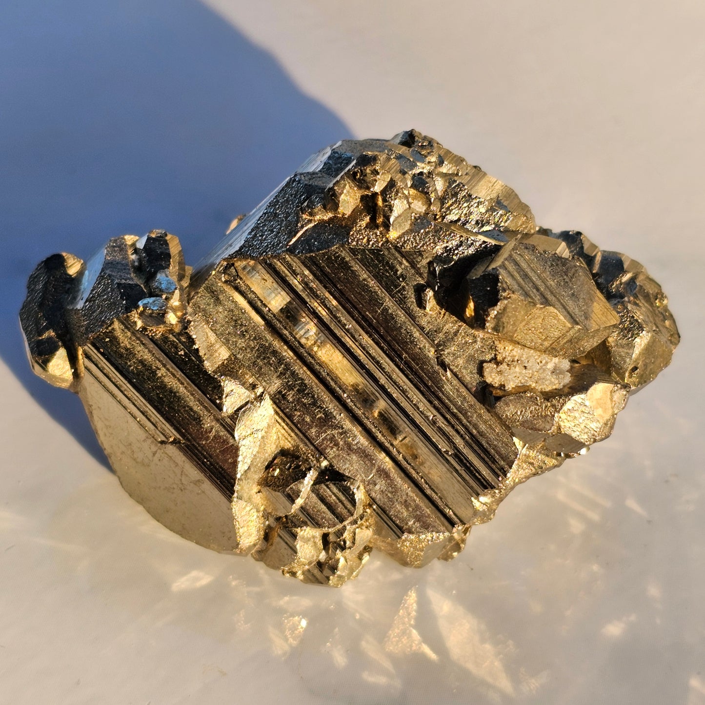 Natural Pyrite cluster in its raw form. This mineral displays a brilliant metallic lustre, with well-defined and sharp parallel striations.