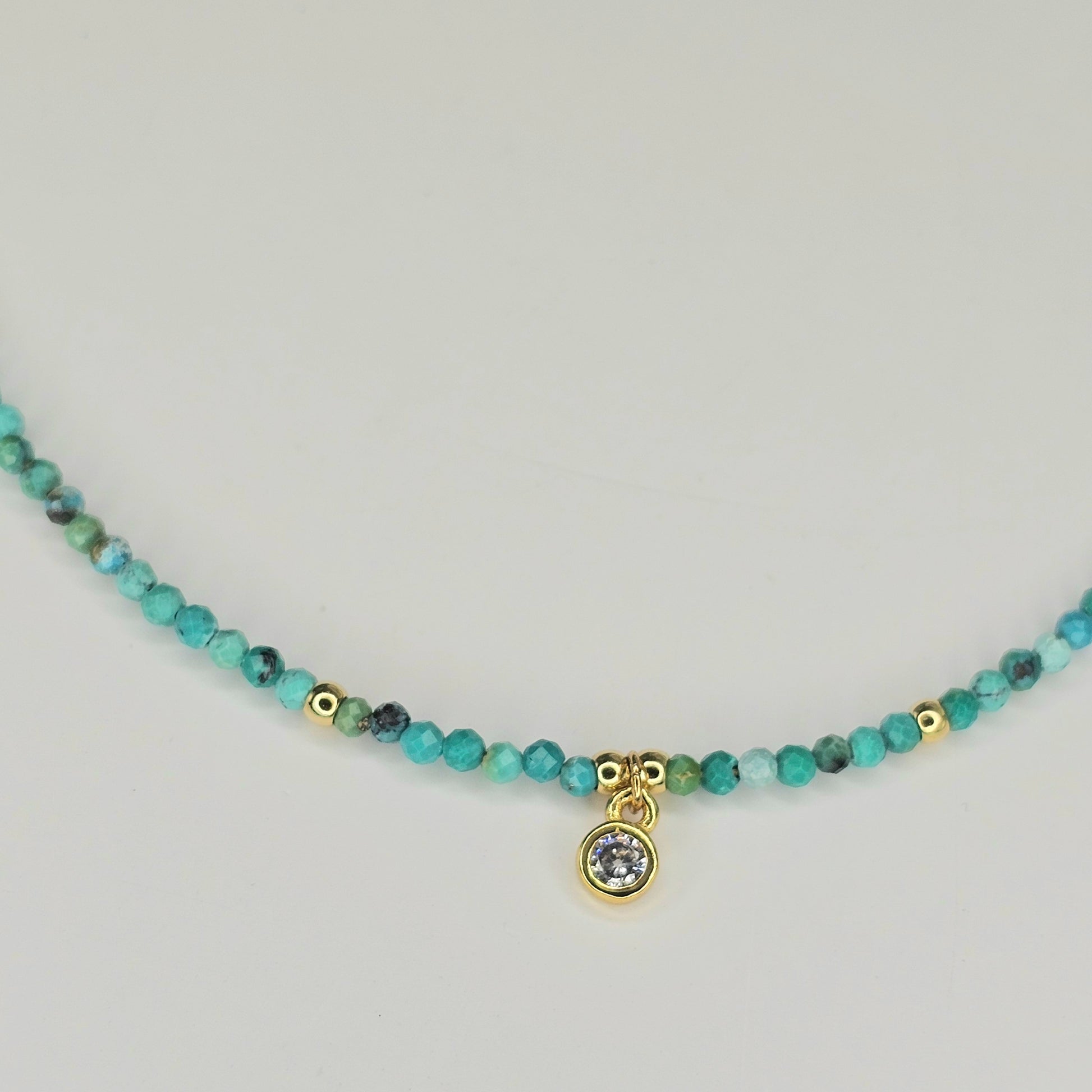 Detailed close-up of the AAA-grade CZ round pendant surrounded by Turquoise beads and gold-toned accents, showing clarity, sparkle, and fine craftsmanship.