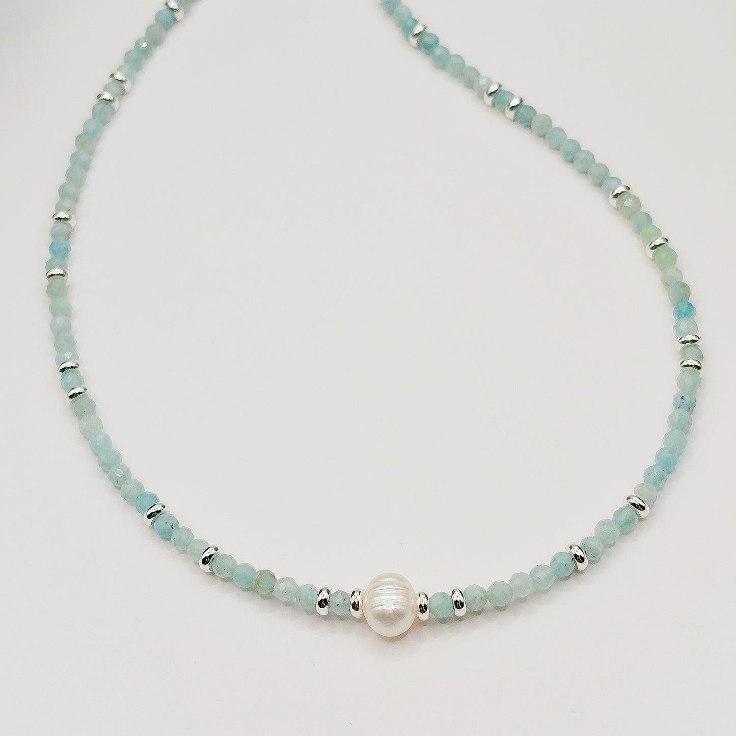 Close detail of Amazonite beads and pearl section laying flat.