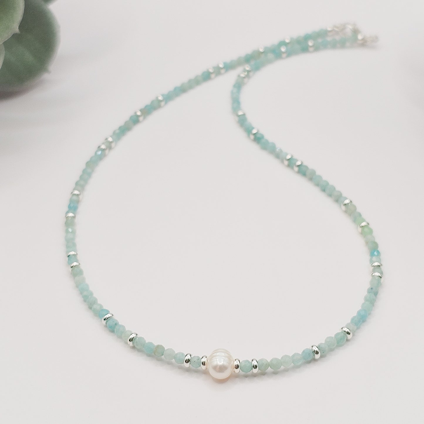 Amazonite and pearl necklace laid flat.
