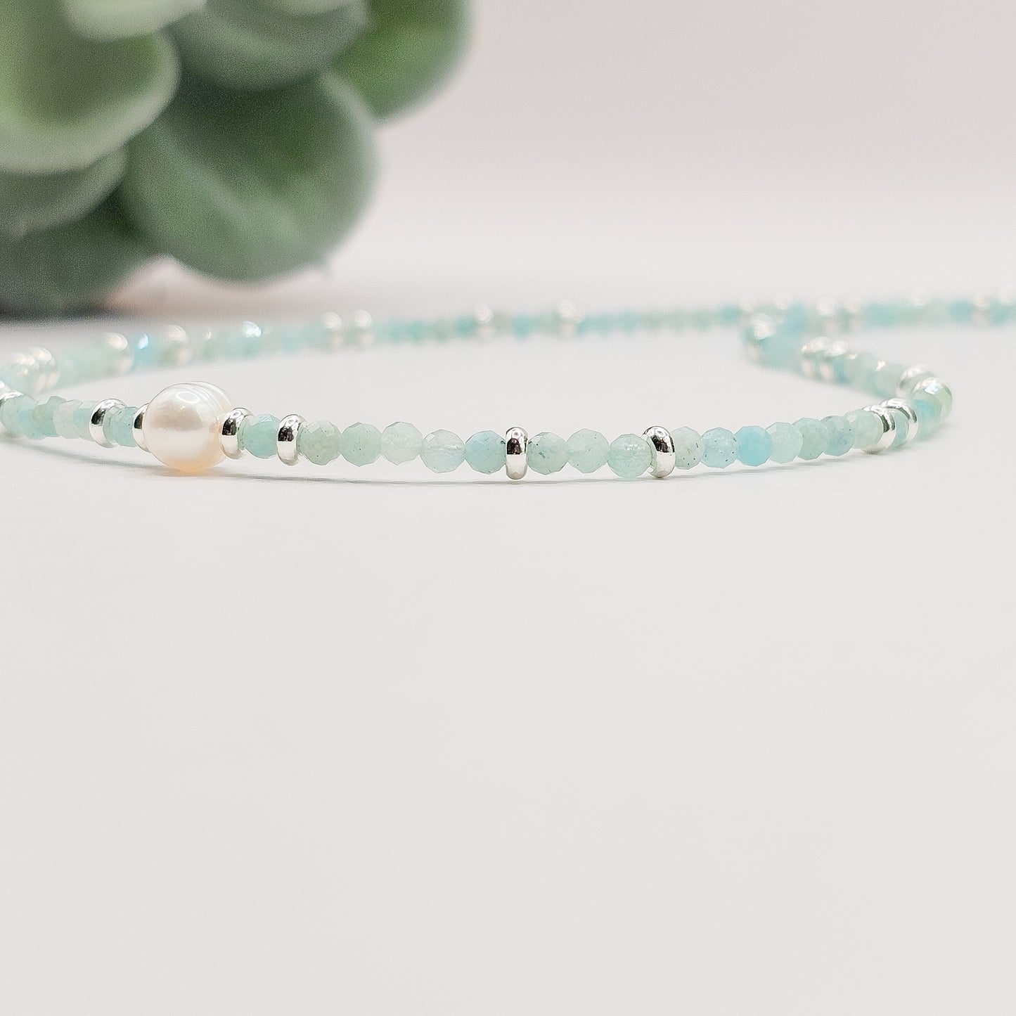 Side flat angle view of Amazonite pearl necklace laid down.