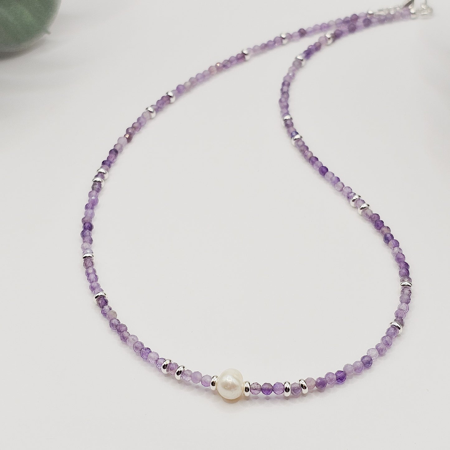 Detail of Amethyst beads and pearl section laying flat.
