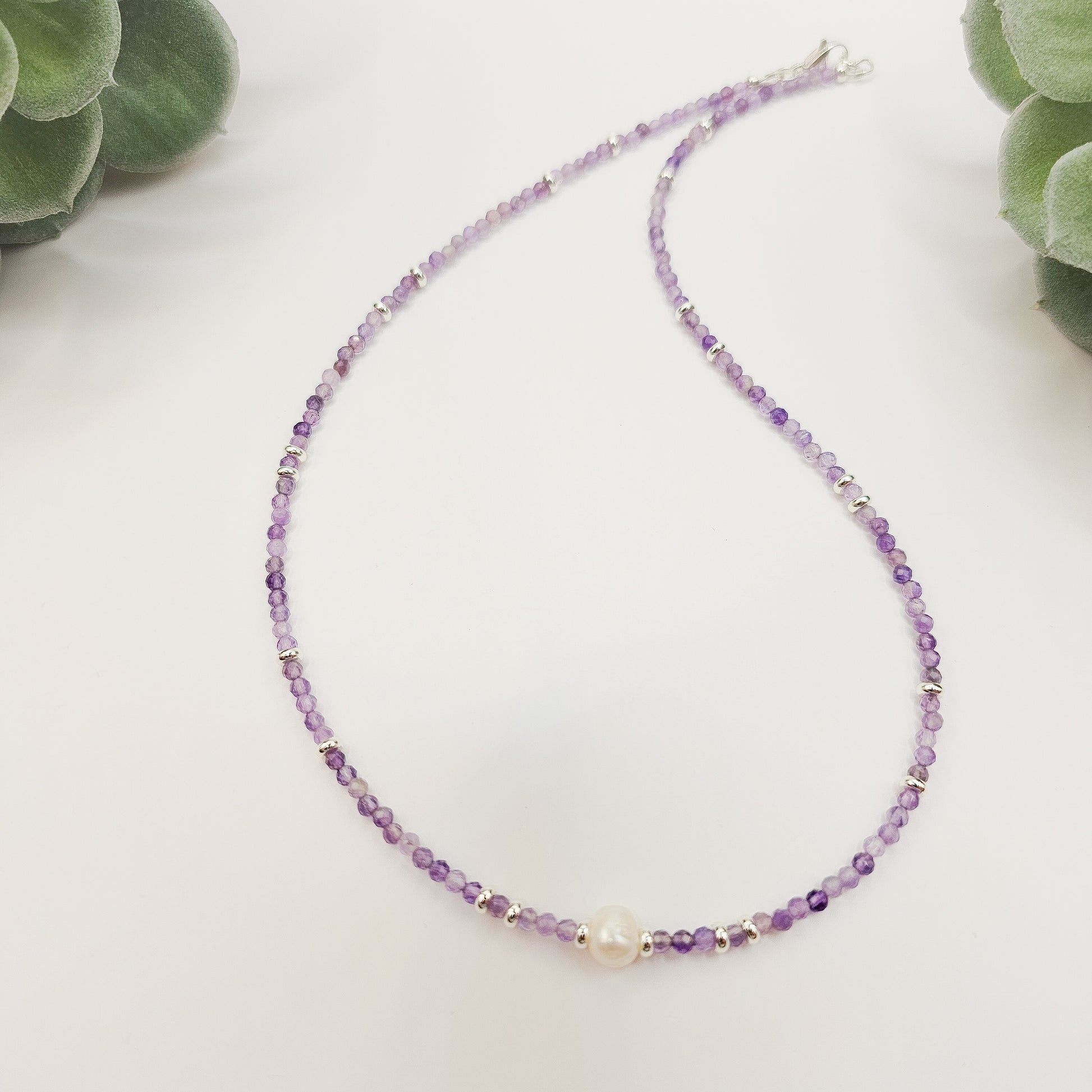 Amethyst and pearl necklace laid flat.