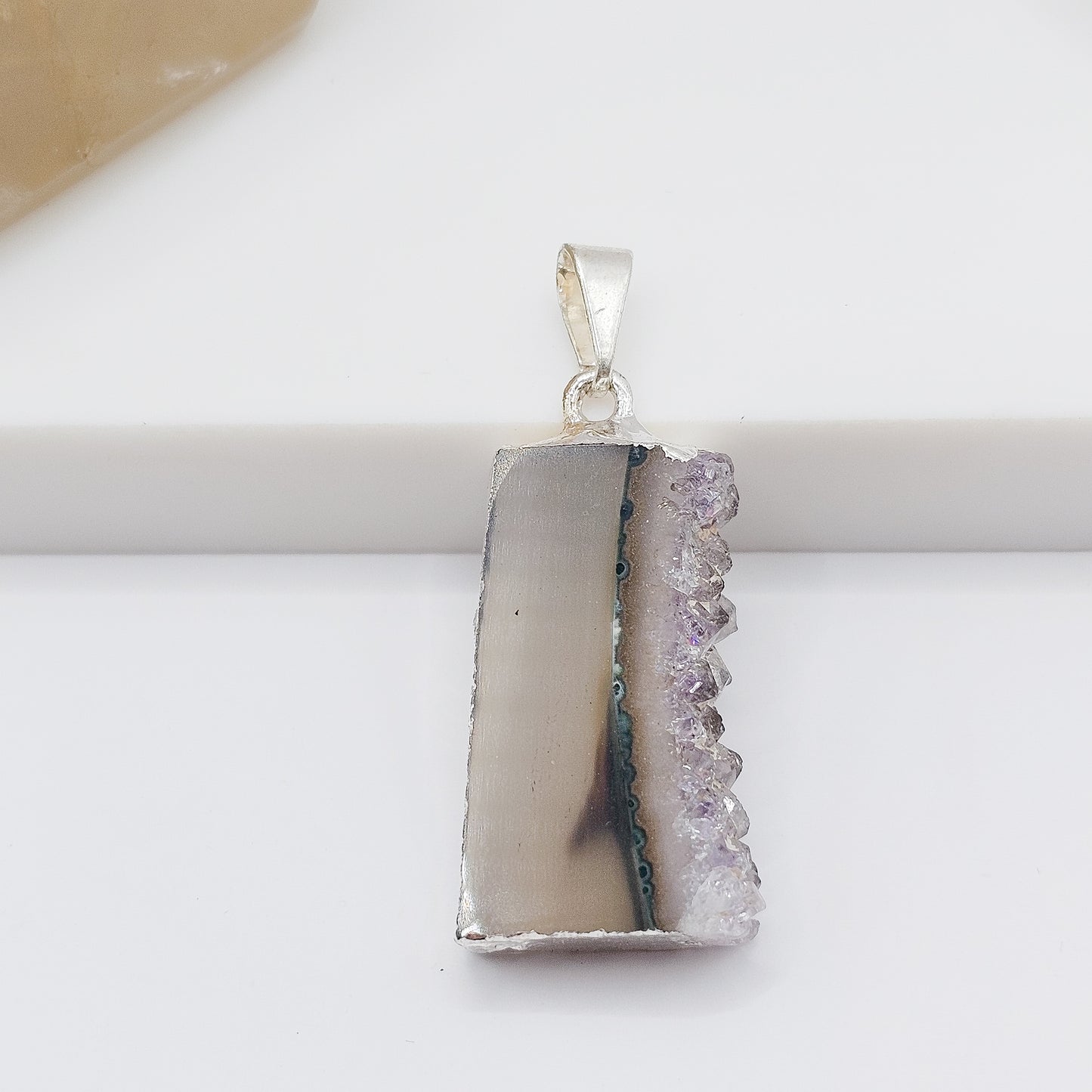 Amethyst stalactite slice pendant showing natural purple crystal formation.