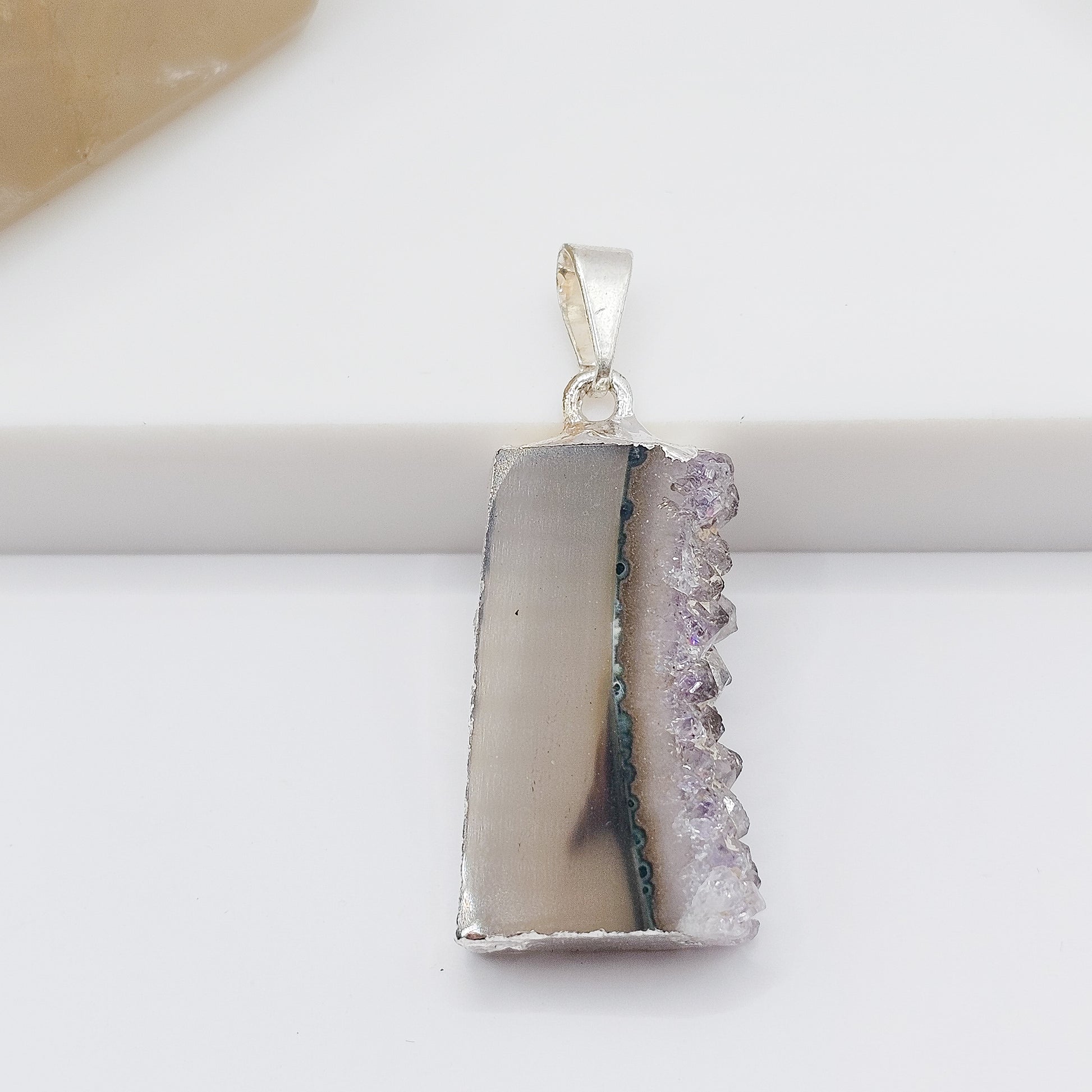 Amethyst stalactite slice pendant showing natural purple crystal formation.