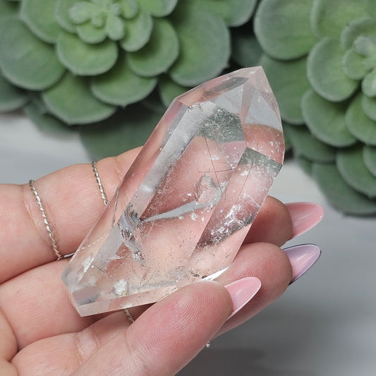 Black Rutile Quartz crystal tower held in hand, showcasing its clarity, fine sparse rutile inclusions, natural key formation, and unique angled display shape.