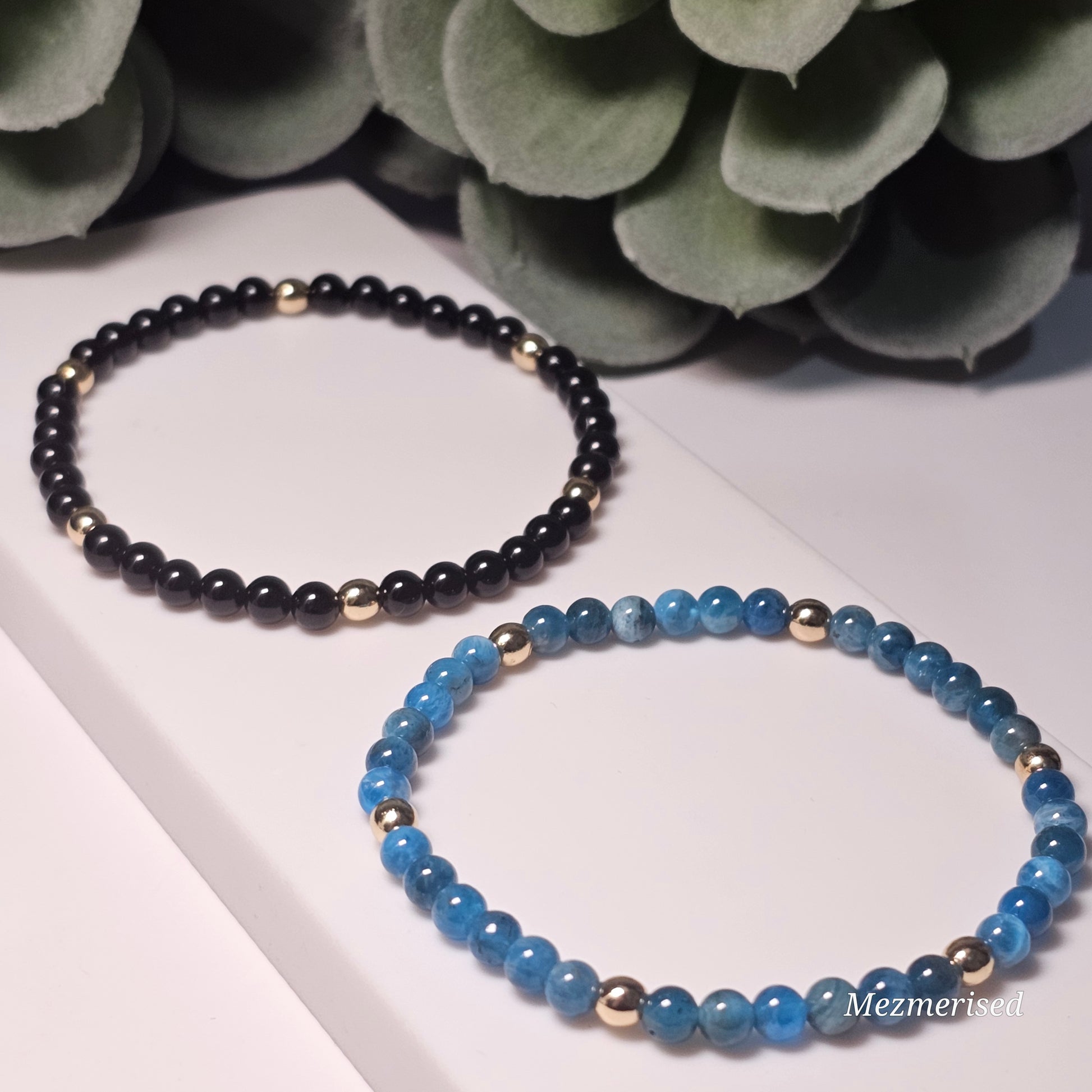Minimal 4mm Black Tourmaline and Blue Apatite bracelets with gold accents styled in flat lay display.