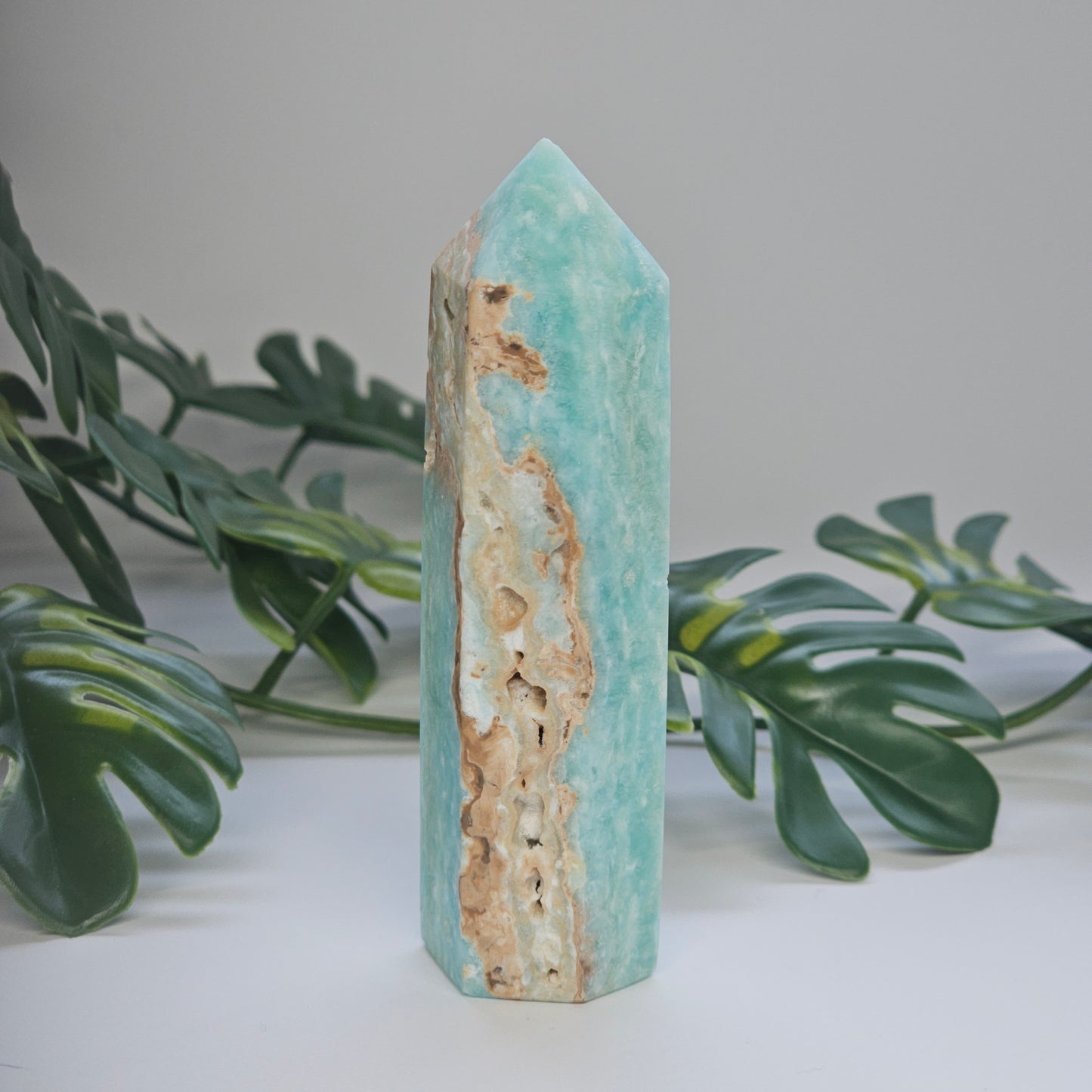 Blue Aragonite tower displaying natural druzy formations and textured crystal surface.