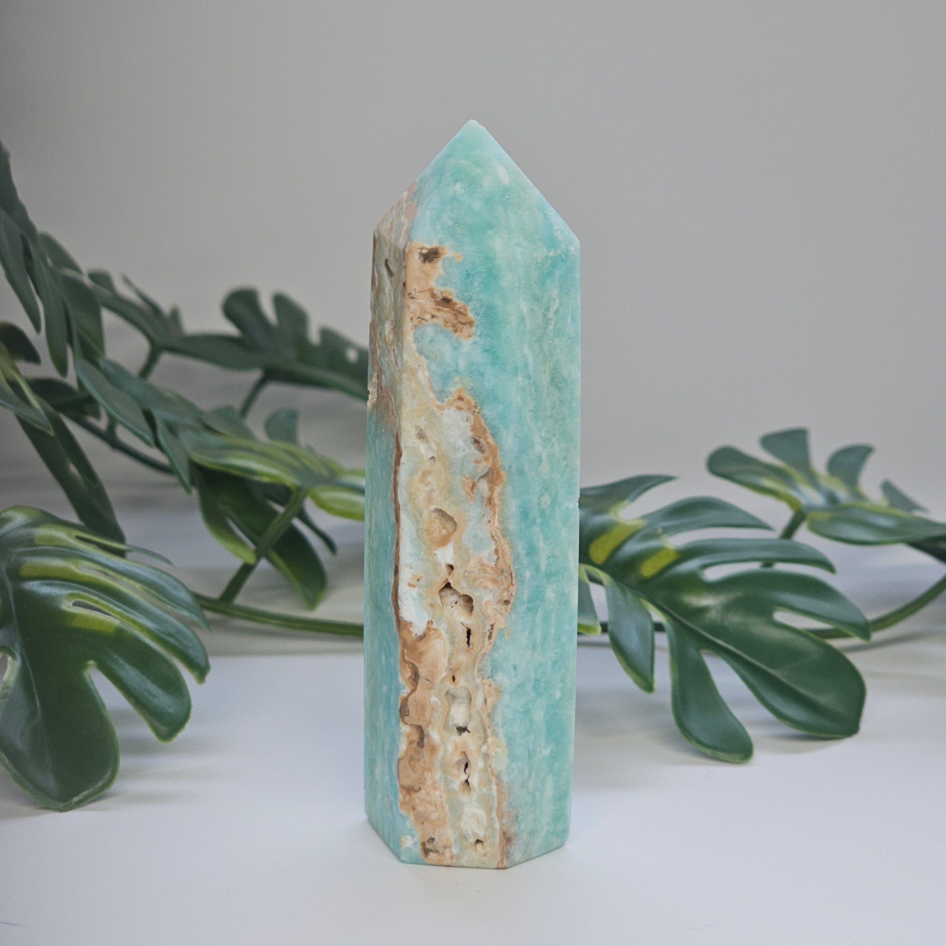 Blue Aragonite tower displaying natural druzy formations and textured crystal surface.