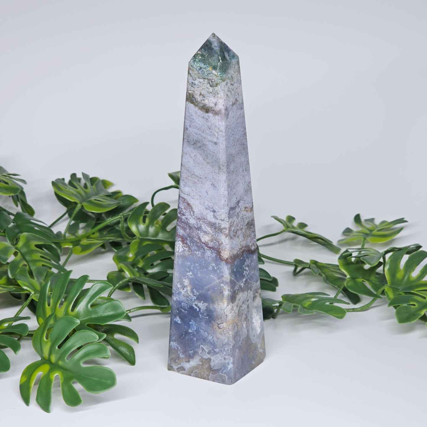 Moss agate crystal tower obelisk displayed as natural home decor statement piece