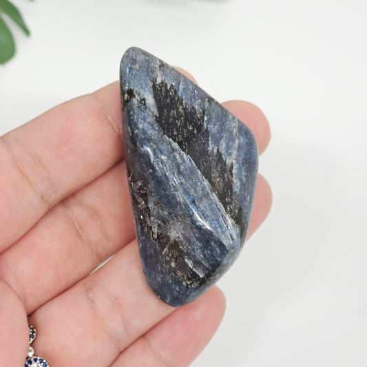 Blue Kyanite polished freeform held in hand, showing deep blue and black tones, smooth polish, and unique natural formations