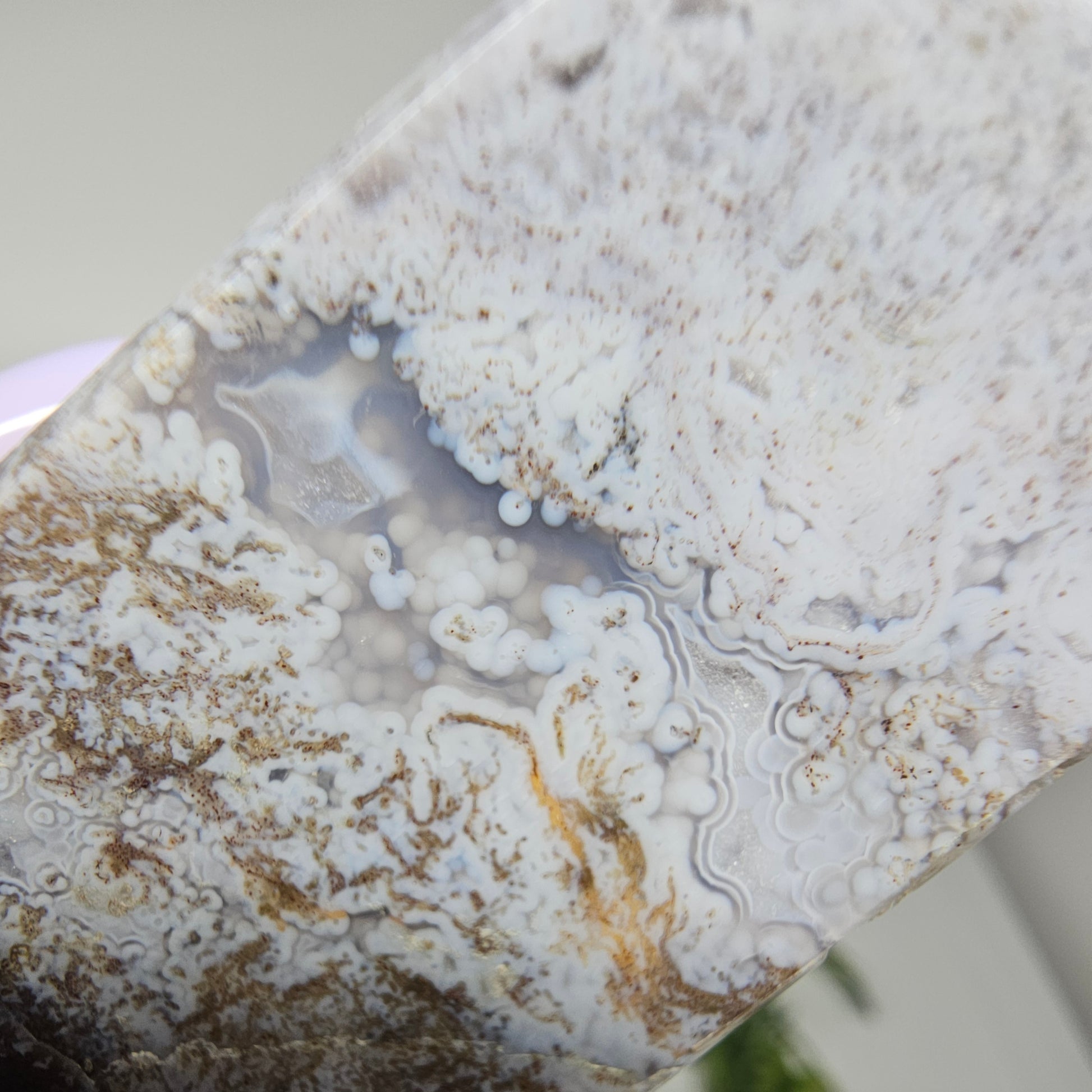 Moss agate crystal tower showing internal botryoidal inclusions through a transparent window of blue chalcedony and natural banded formation detail