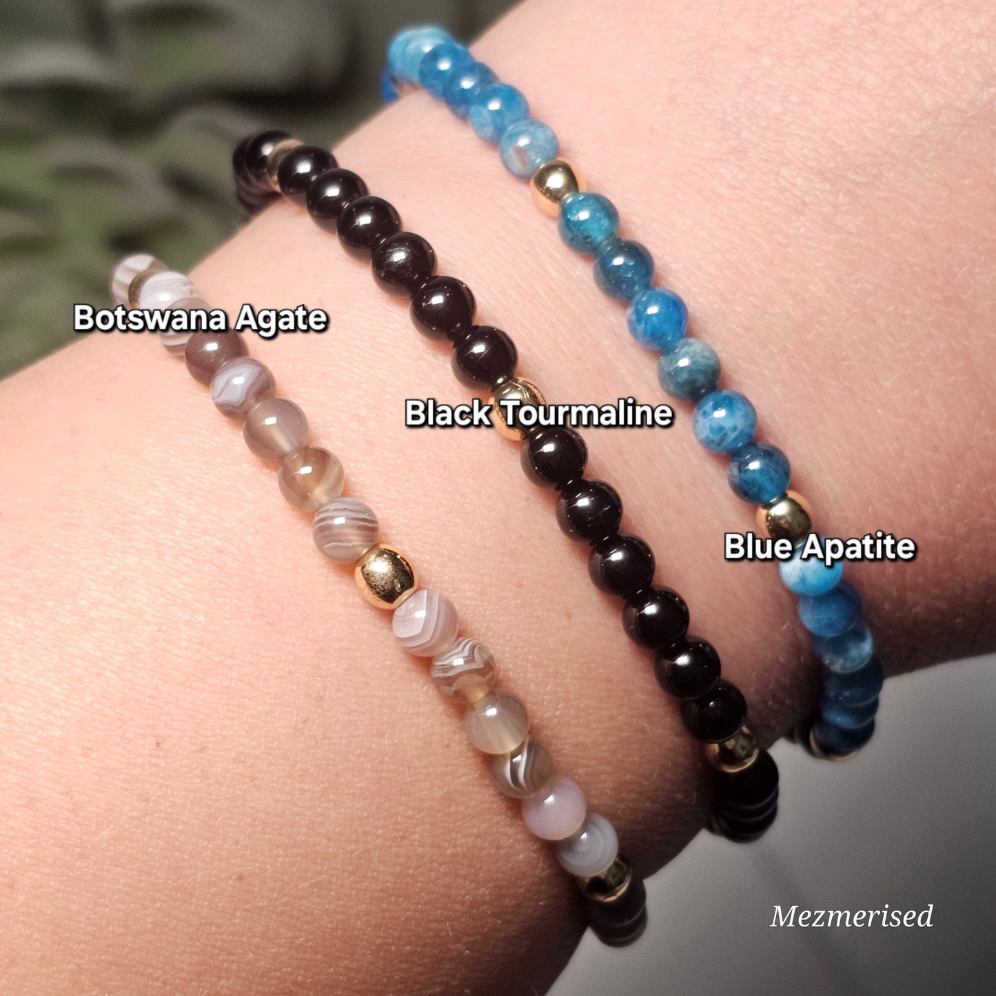 Stacked 4mm Botswana Agate, Black Tourmaline and Blue Apatite gemstone bracelets with minimalist gold accent details.